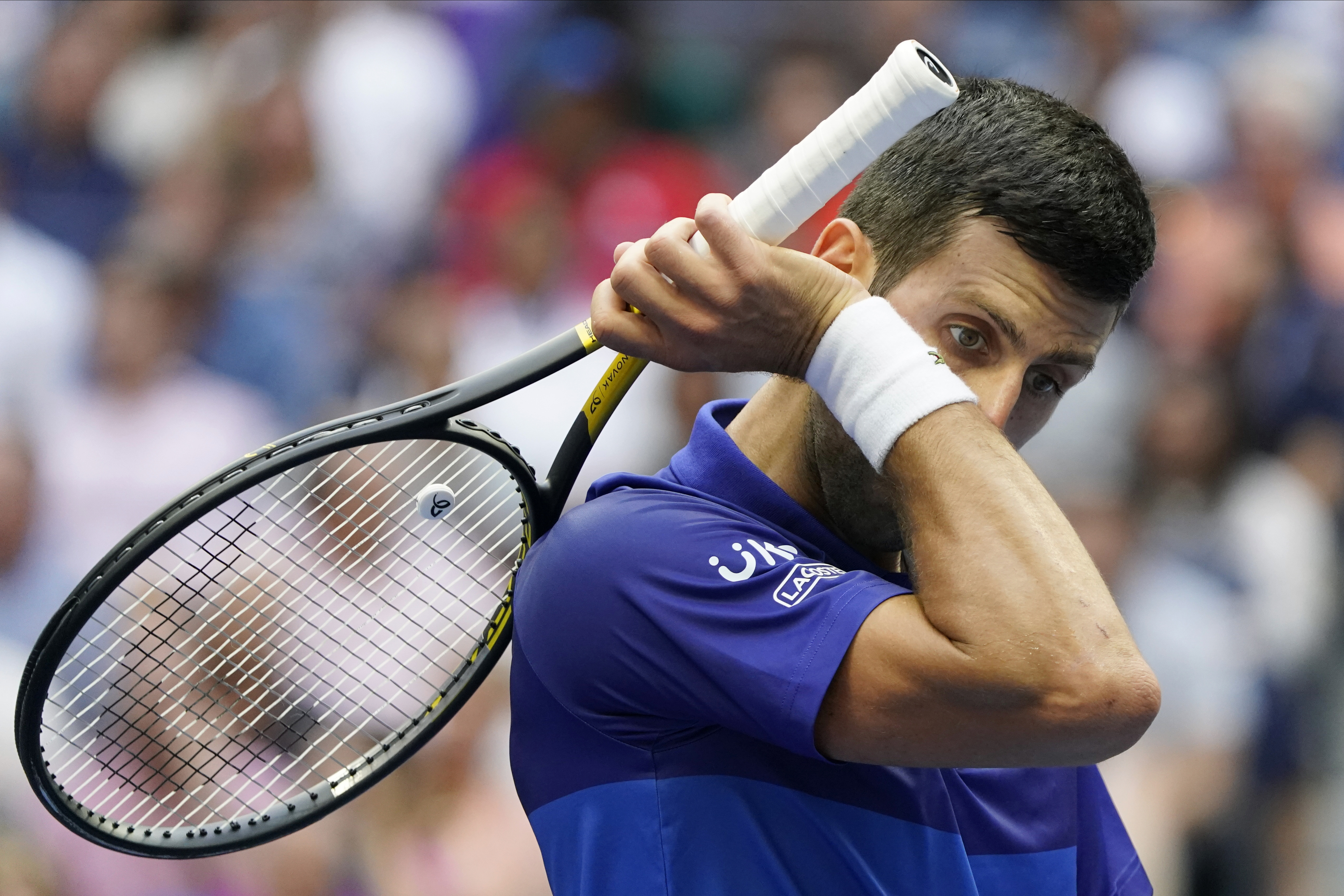 Novak Djokovic, of Serbia, wipes sweat from his face between points during the men's singles final of the US Open tennis championships against Daniil Medvedev, of Russia, Sunday, Sept. 12, 2021, in New York. (AP Photo/John Minchillo)