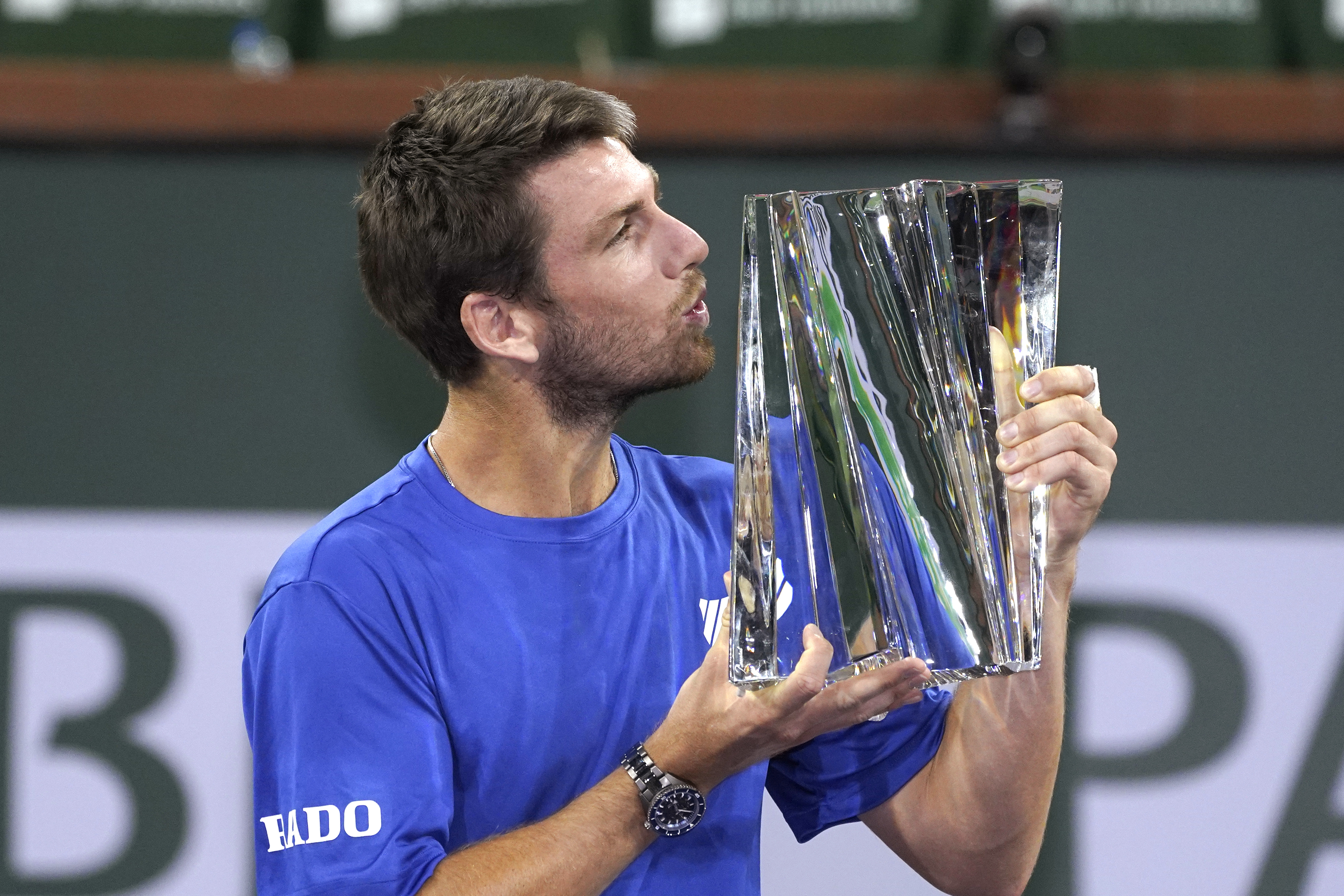 Cameron Norrie, of Britain, puts his lips to his trophy after defeating Nikoloz Basilashvili, of Georgia, in the singles final at the BNP Paribas Open tennis tournament Sunday, Oct. 17, 2021, in Indian Wells, Calif. (AP Photo/Mark J. Terrill)