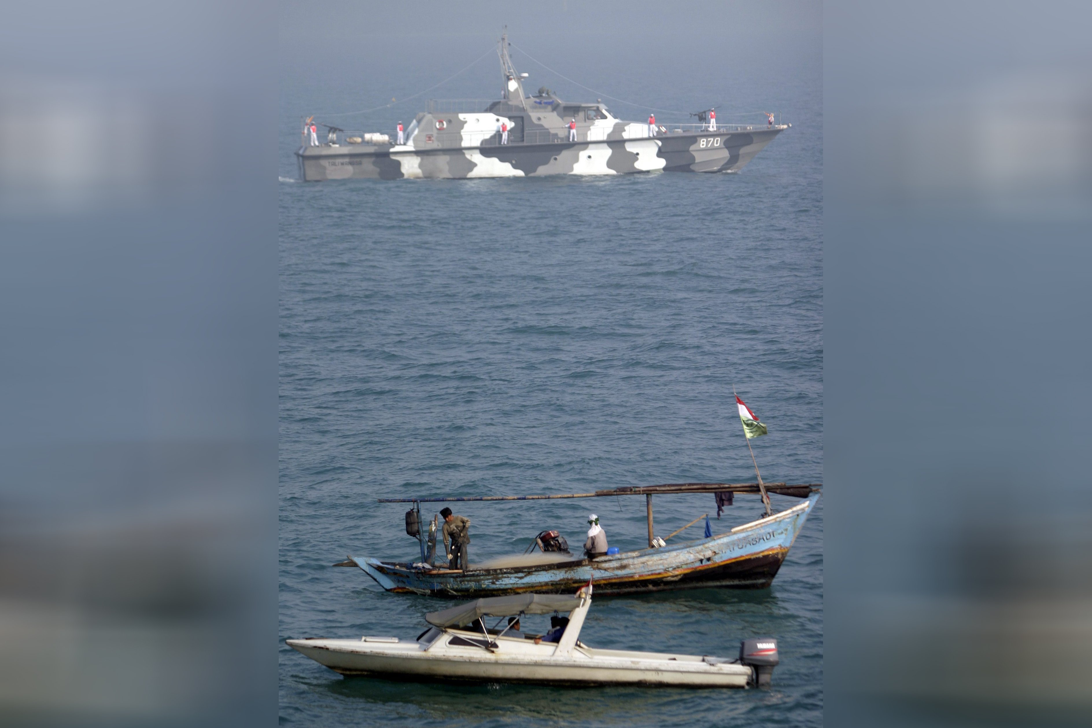 Indonezija brod, Two Indonesian fisher boat pass by a brand new naval patrol ship made by Indonesian state own military company during a formal ceremony at bay of Jakarta, Indonesia