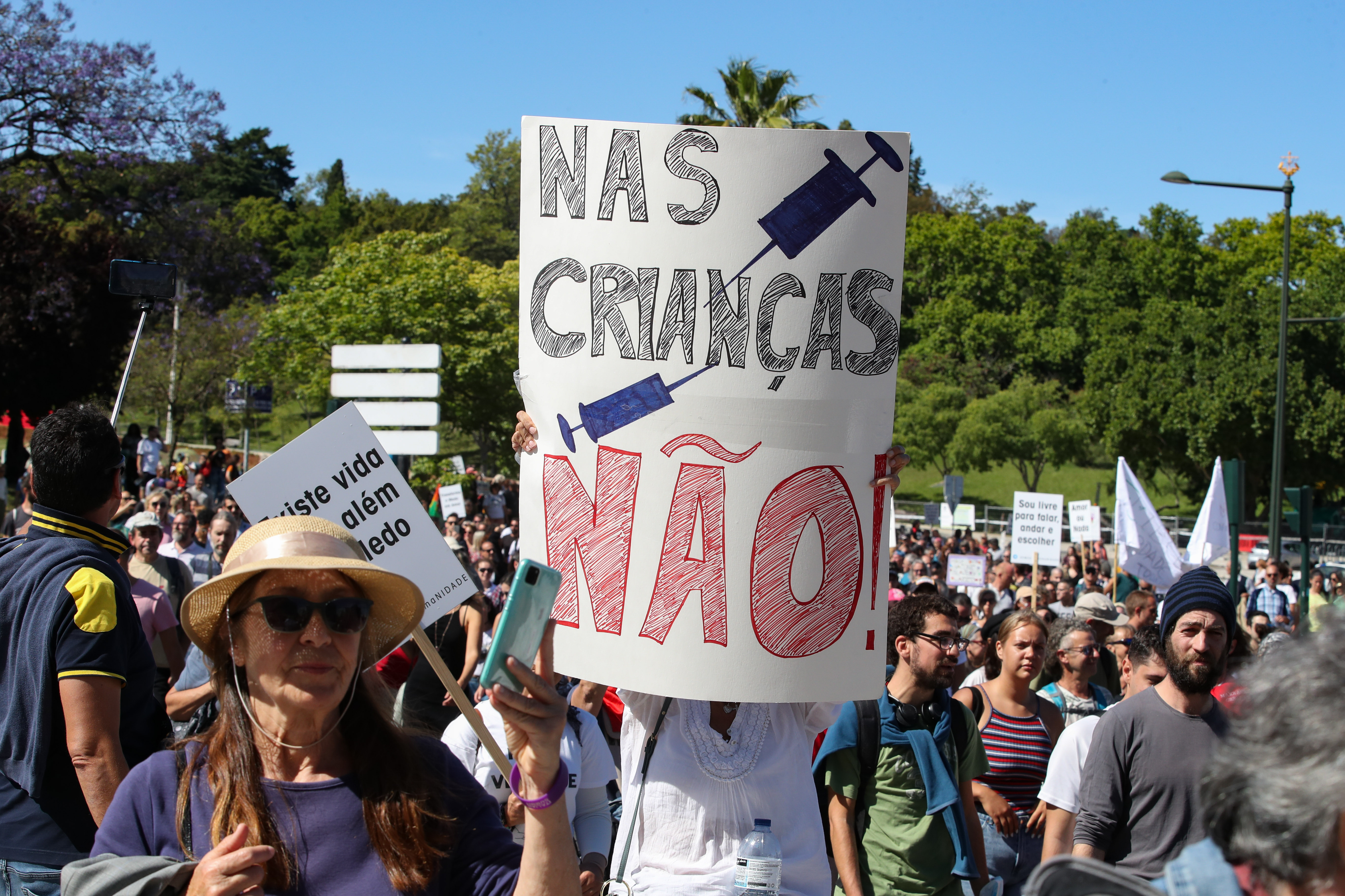 epa09202450 A banner reads 'not in children' as hundreds of protesters during a march against restrictions imposed by the Portuguese government to try to stop the Covid-19 pandemic, in Lisbon downtown, Portugal, 15 May 2021.  EPA-EFE/MANUEL DE ALMEIDA