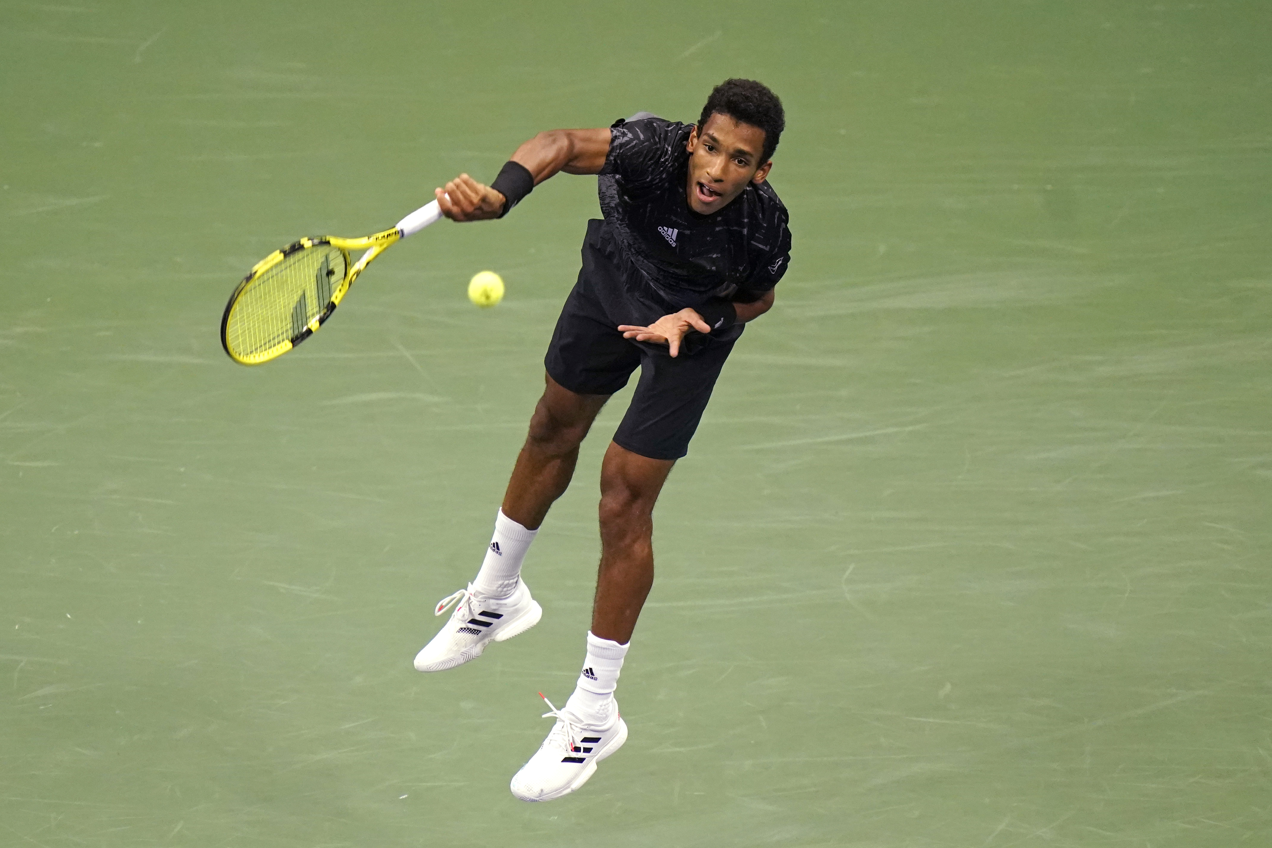 Felix Auger-Aliassime, of Canada, serves to Carlos Alcaraz, of Spain, during the quarterfinals of the U.S. Open tennis tournament Tuesday, Sept. 7, 2021, in New York. Auger-Aliassime won the match after Alcaraz withdrew. (AP Photo/Frank Franklin II)