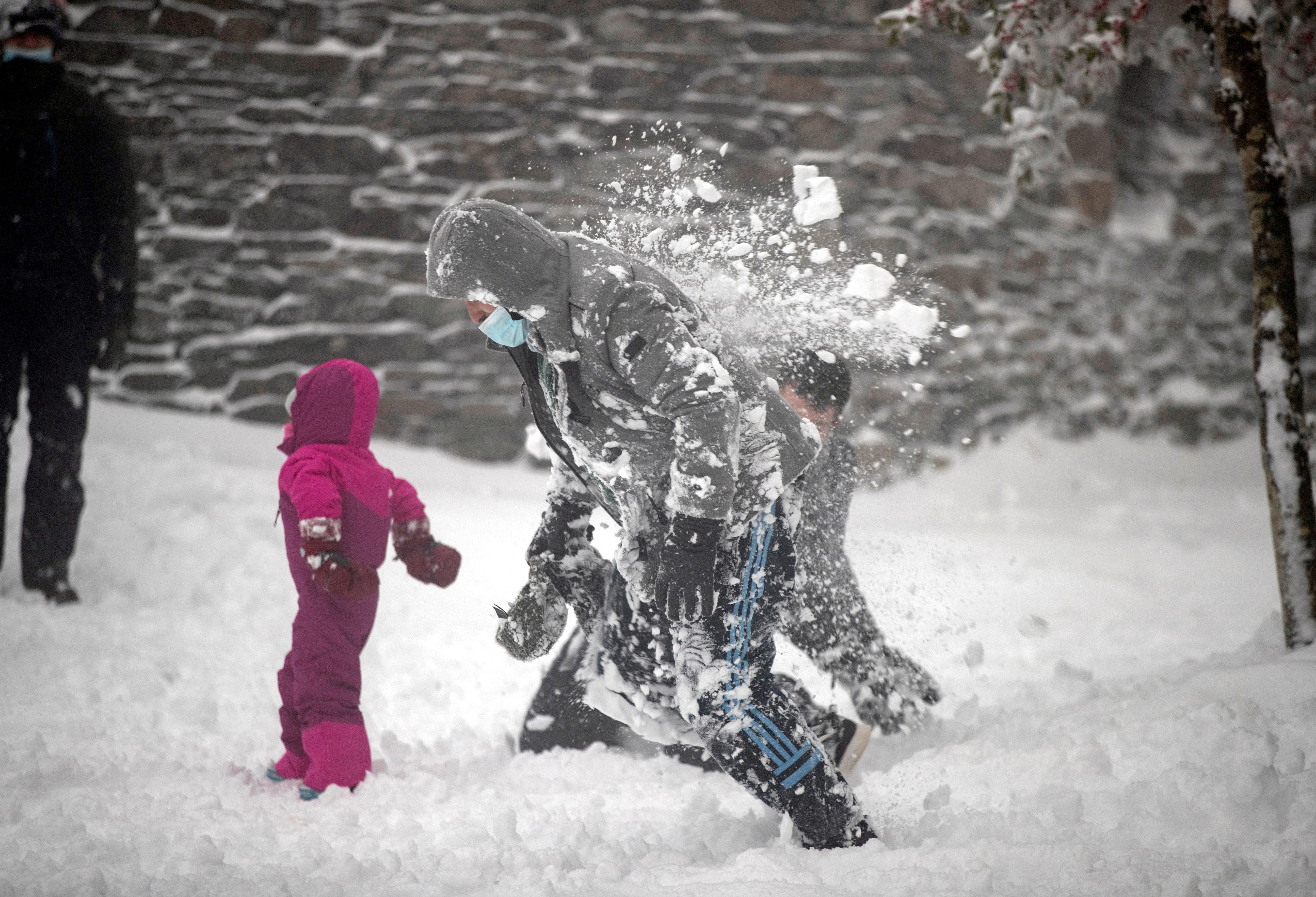epa08908356 People enjoy of the snow at the village of O Cebreiro, Lugo, Galicia, northwestern Spain, 28 December 2020. Meteorologists expect storm 'Bella' to bring heavy rains and strong winds on its way through the country.  EPA-EFE/Eliseo Trigo