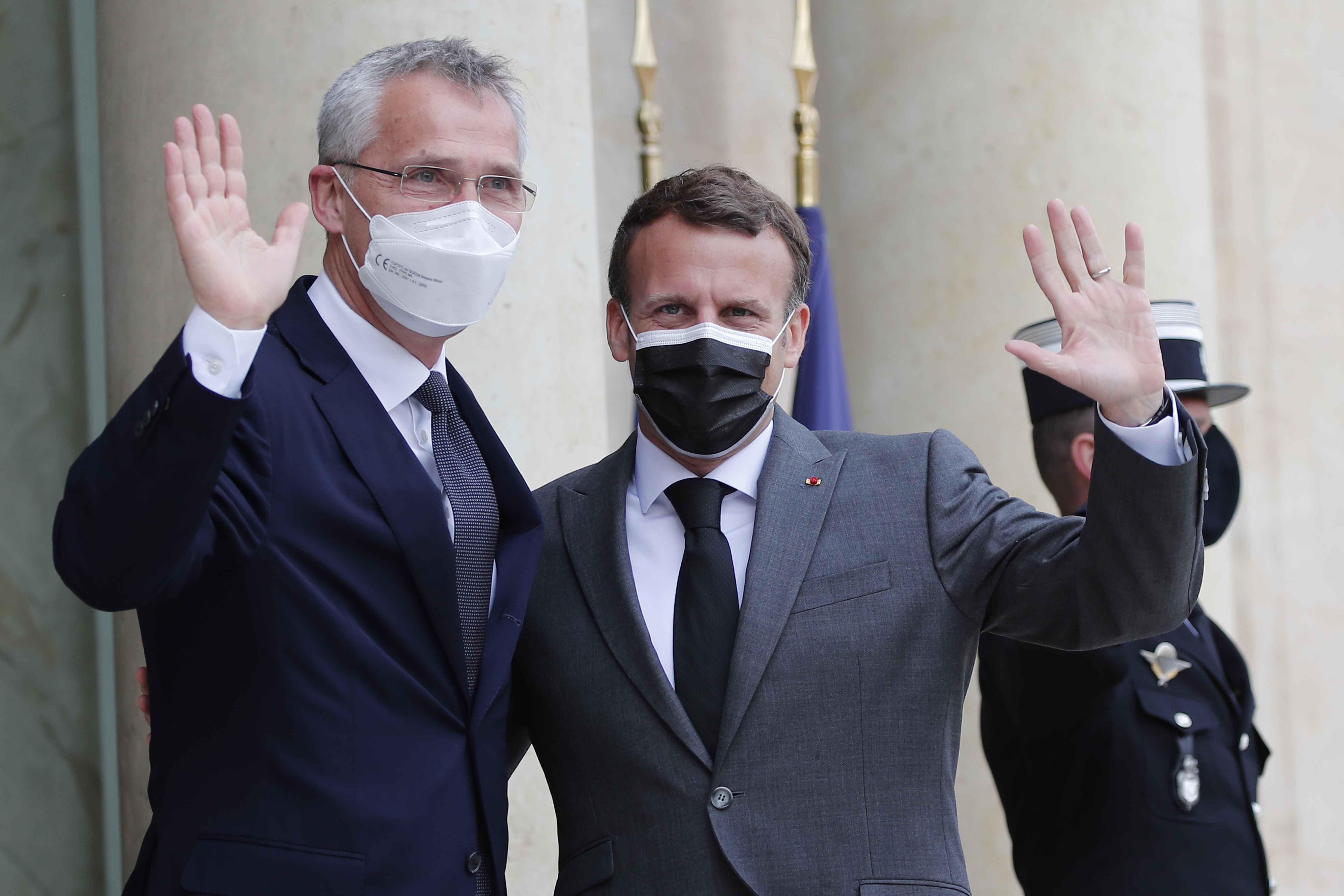 French President Emmanuel Macron, right, and NATO Secretary General Jens Stoltenberg wave to journalists before their talks Friday, May 21, 2021 at the Elysee palace in Paris. (AP Photo/Francois Mori)