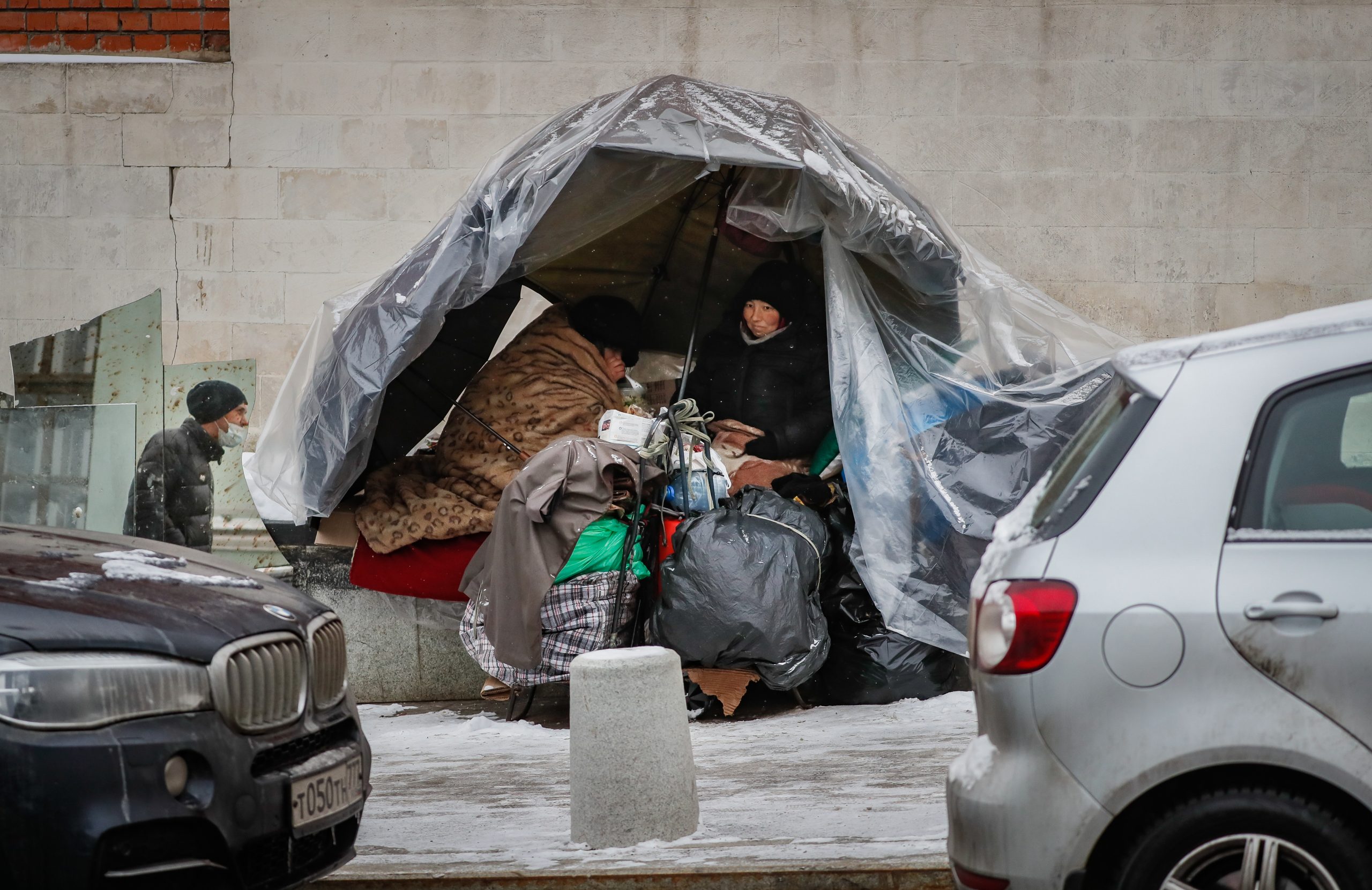 epa08931583 Homeless women eat in their hut on the street in center of Moscow, Russia, 11 January 2021 during the pandemic of SARS-CoV-2 coronavirus.  EPA-EFE/YURI KOCHETKOV