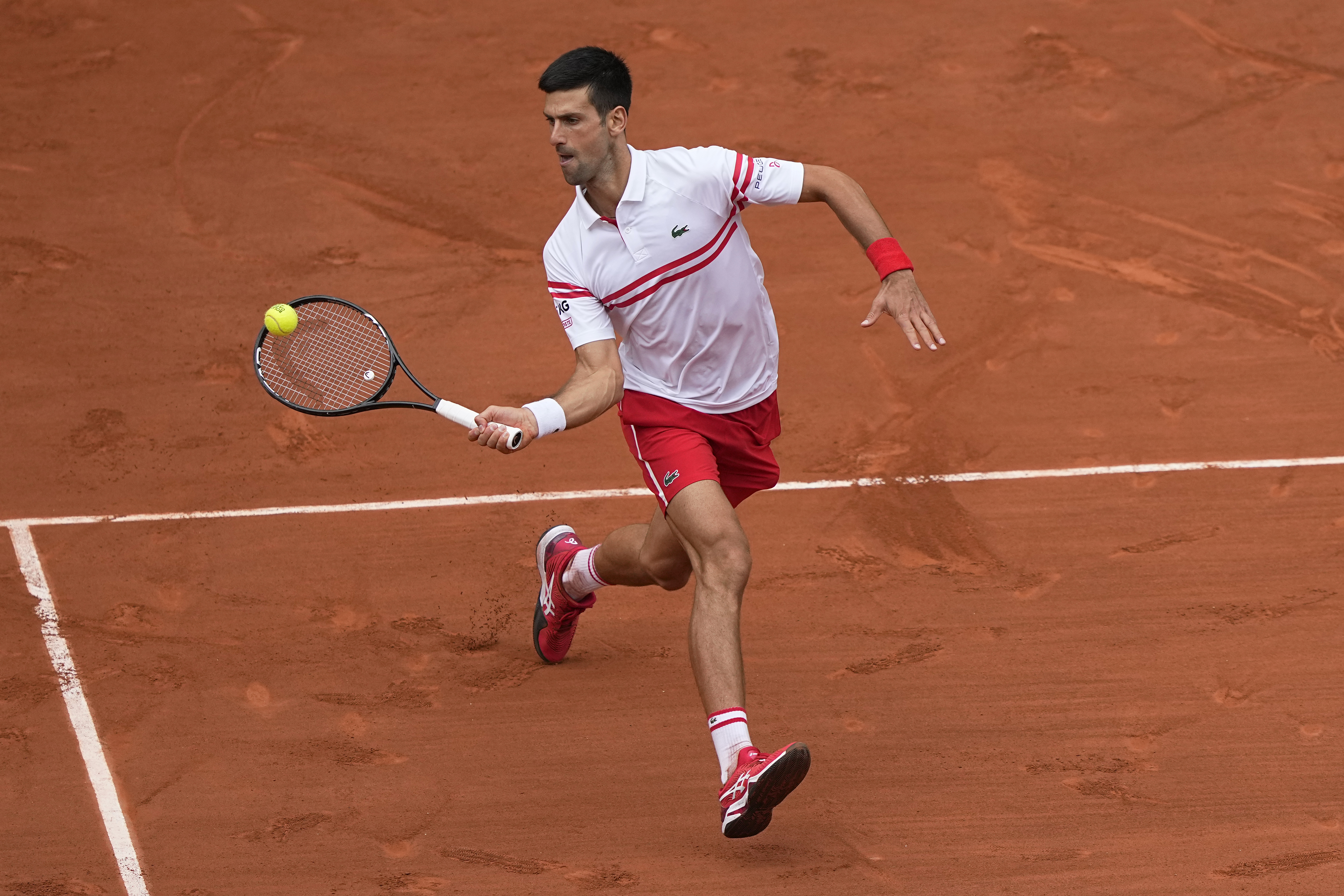 Serbia's Novak Djokovic plays a return to Italy's Lorenzo Musetti during their fourth round match on day 9, of the French Open tennis tournament at Roland Garros in Paris, France, Monday, June 7, 2021. (AP Photo/Michel Euler)