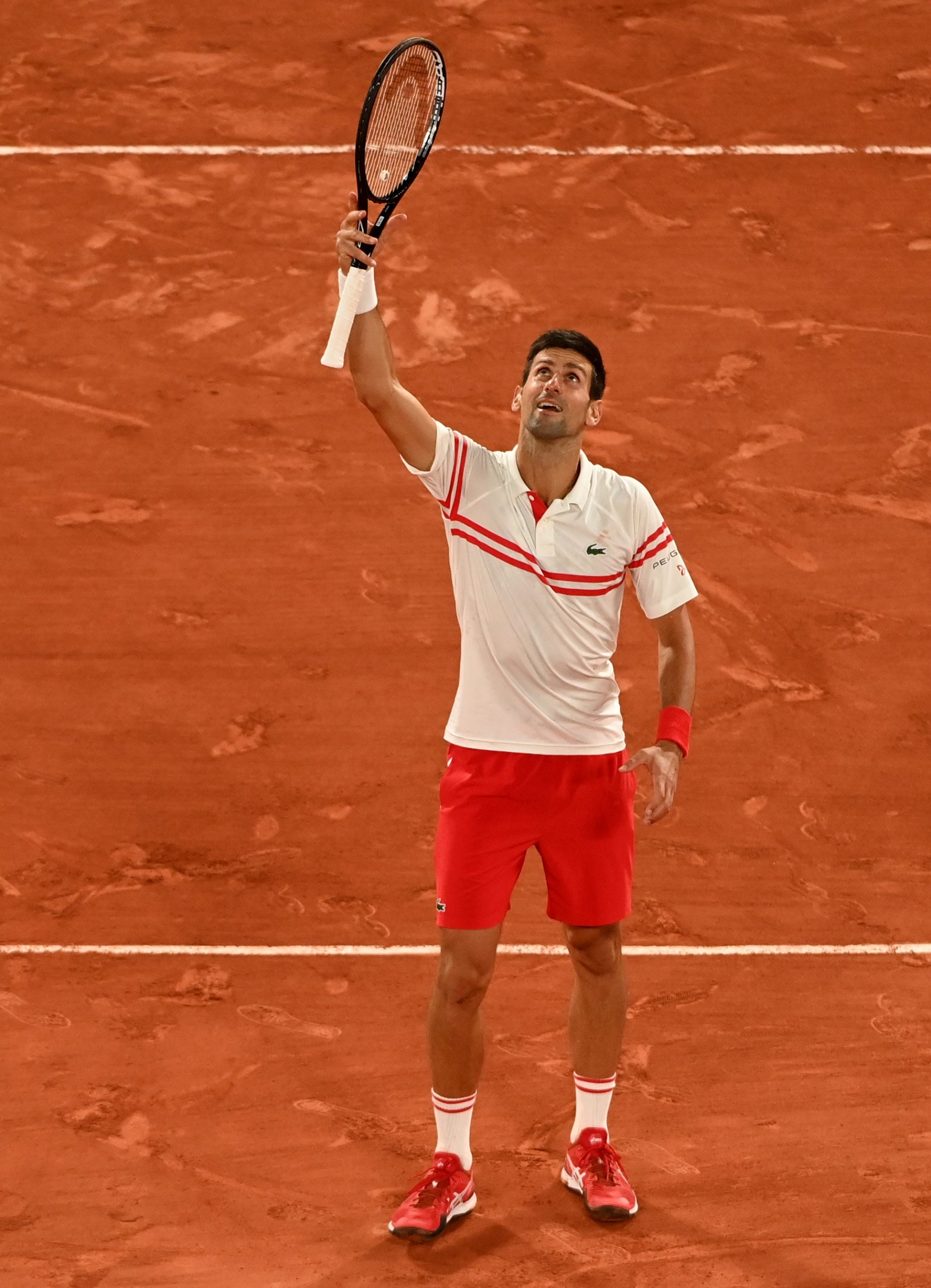 epa09263588 Novak Djokovic of Serbia celebrates winning against Rafael Nadal of Spain during their semi final match at the French Open tennis tournament at Roland Garros in Paris, France, 11 June 2021.  EPA-EFE/CAROLINE BLUMBERG