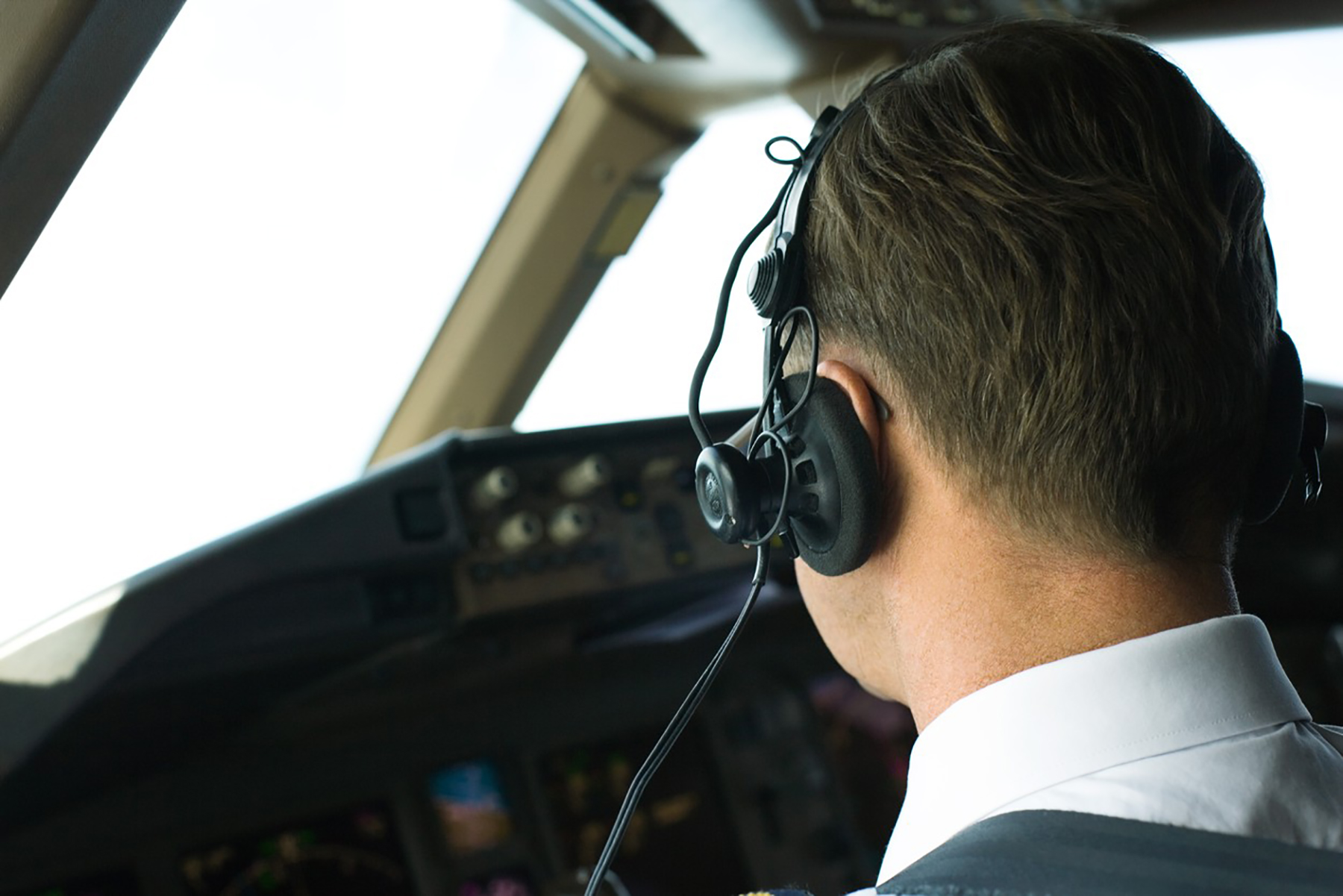 Pilot wearing headphones, rear view, close-up pilot