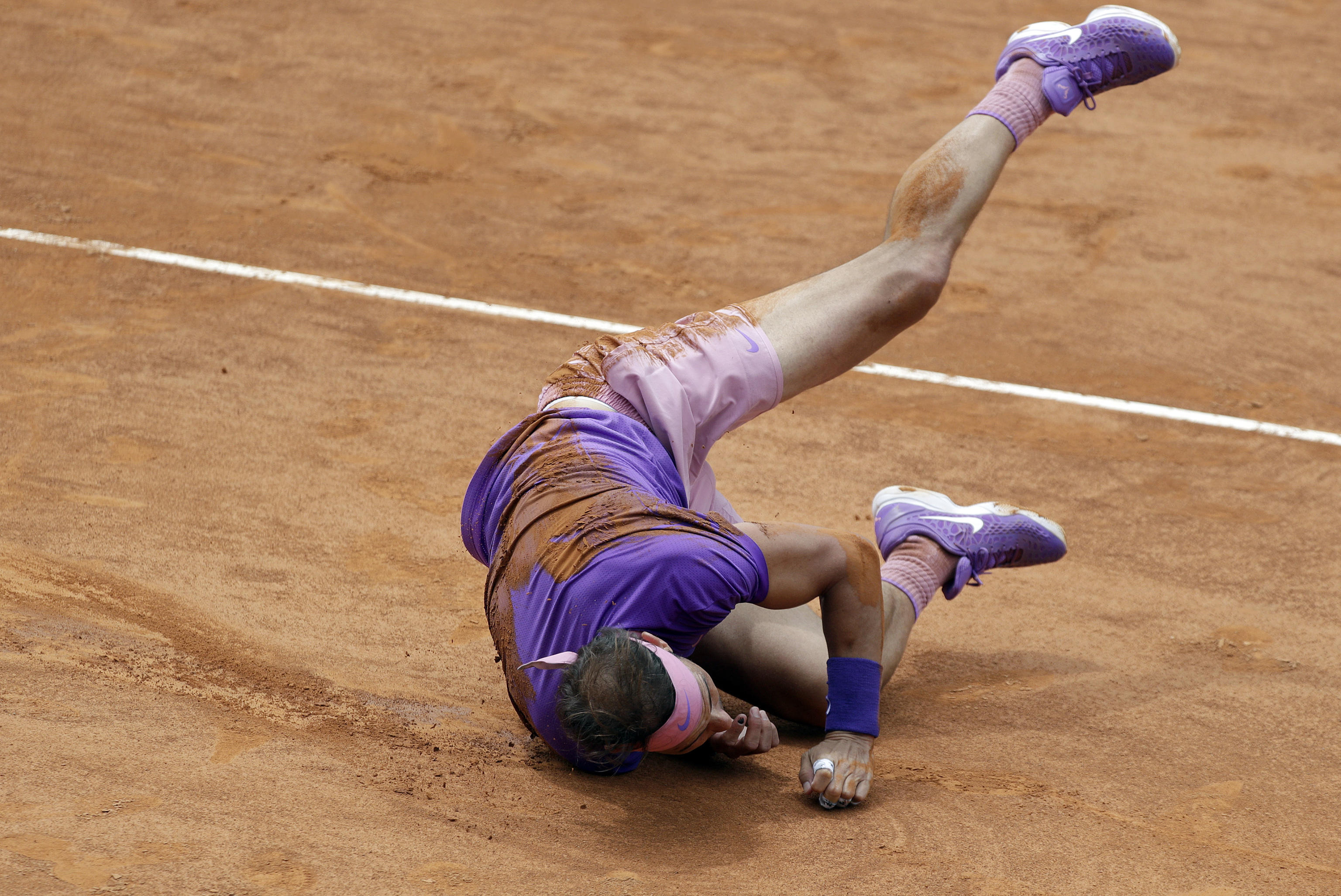 epa09199247 Rafael Nadal of Spain falls during his men's singles quarter final match against Alexander Zverev of Germany at the Italian Open tennis tournament in Rome, Italy, 14 May 2021.  EPA-EFE/ETTORE FERRARI