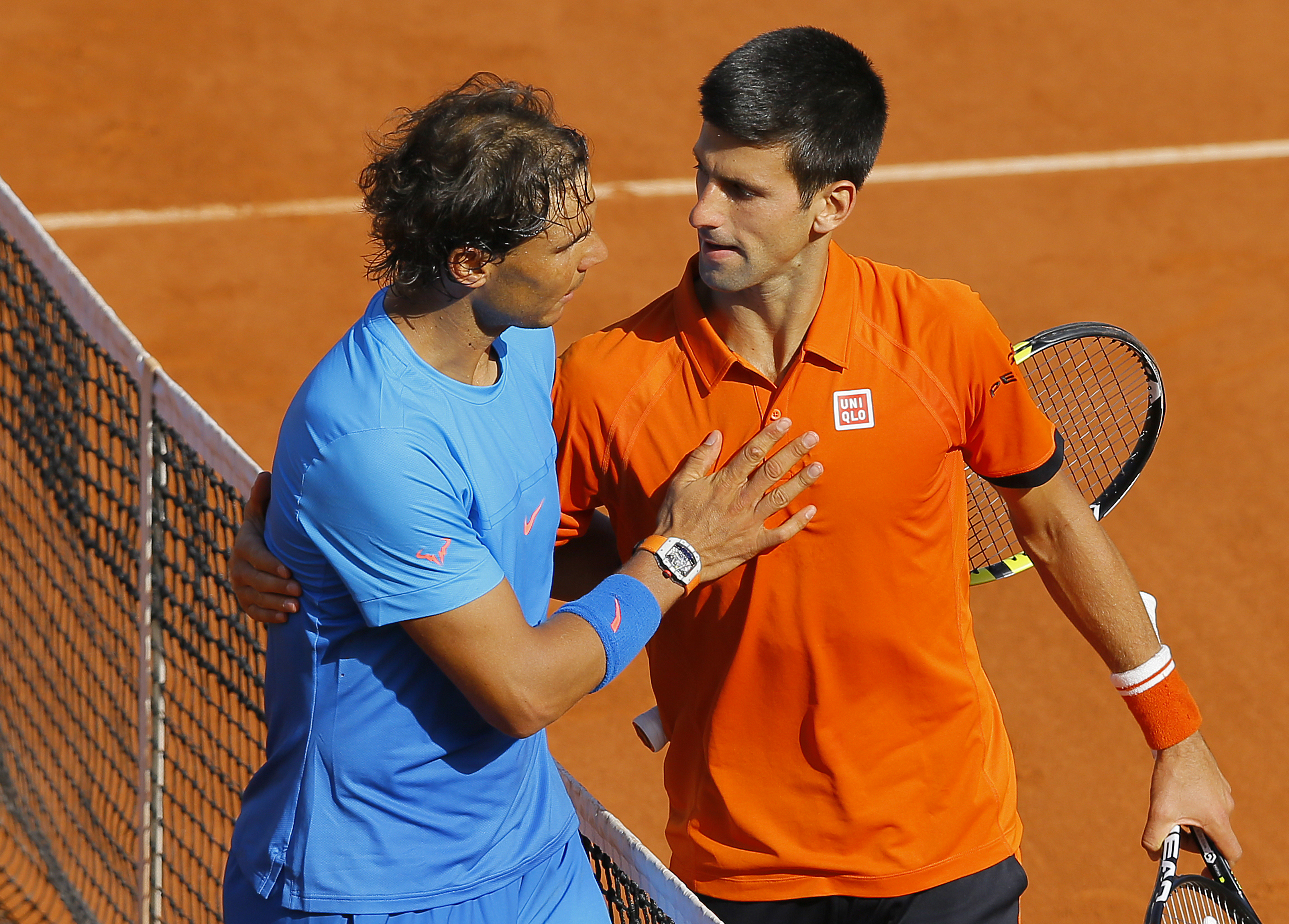 epa04781905 Novak Djokovic of Serbia (R) hugs after winning against Rafael Nadal of Spain during their quarterfinal match for the French Open tennis tournament at Roland Garros in Paris, France, 03 June 2015.  EPA/ROBERT GHEMENT