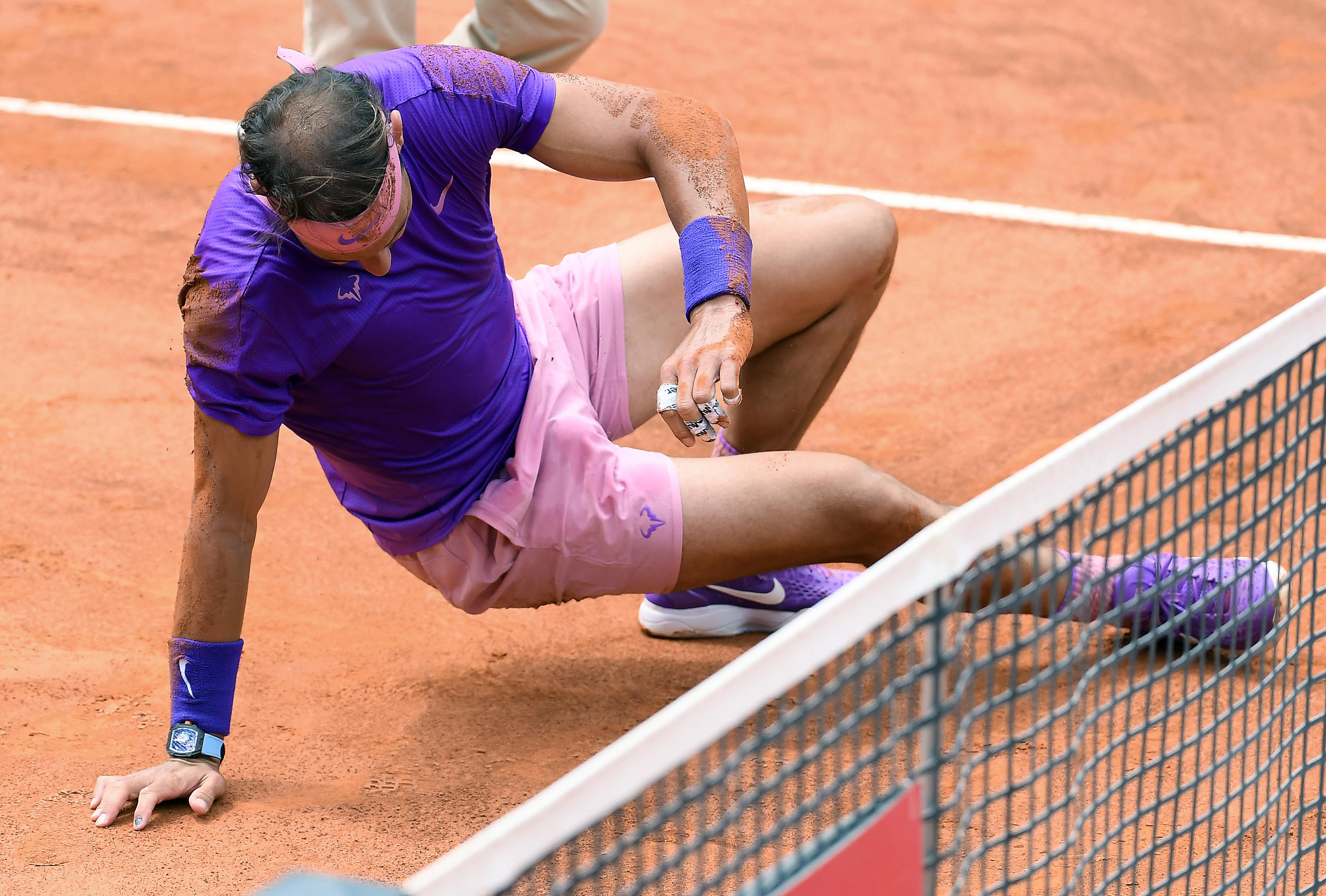 epa09199282 Rafael Nadal of Spain falls during his men's singles quarter final match against Alexander Zverev of Germany at the Italian Open tennis tournament in Rome, Italy, 14 May 2021.  EPA-EFE/ETTORE FERRARI