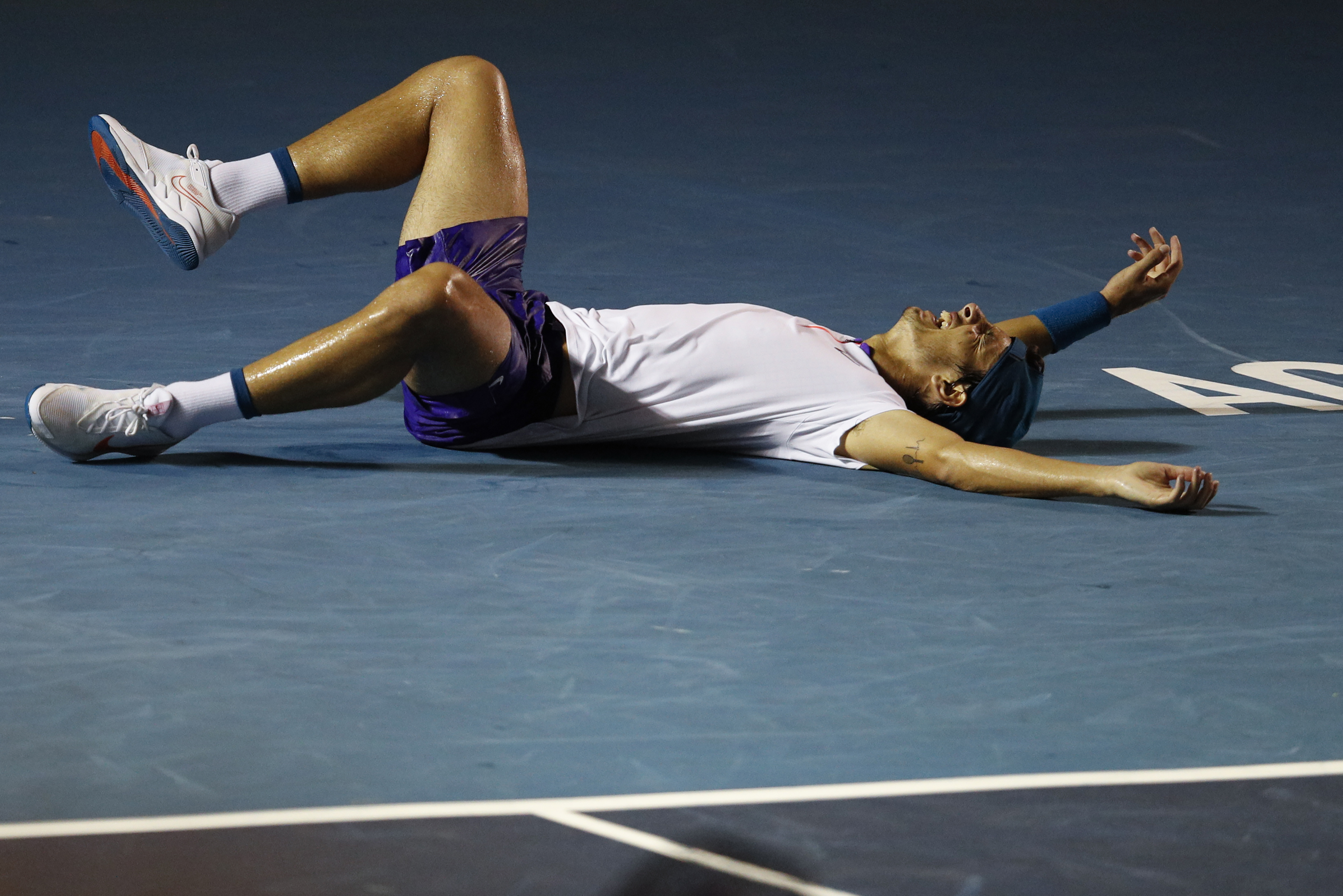 Italy's Lorenzo Musetti rolls on the court as he celebrates winning his quarterfinal match against Bulgaria's Grigor Dimitrov at the Mexican Open tennis tournament in Acapulco, Friday, March 19, 2021. (AP Photo/Rebecca Blackwell)