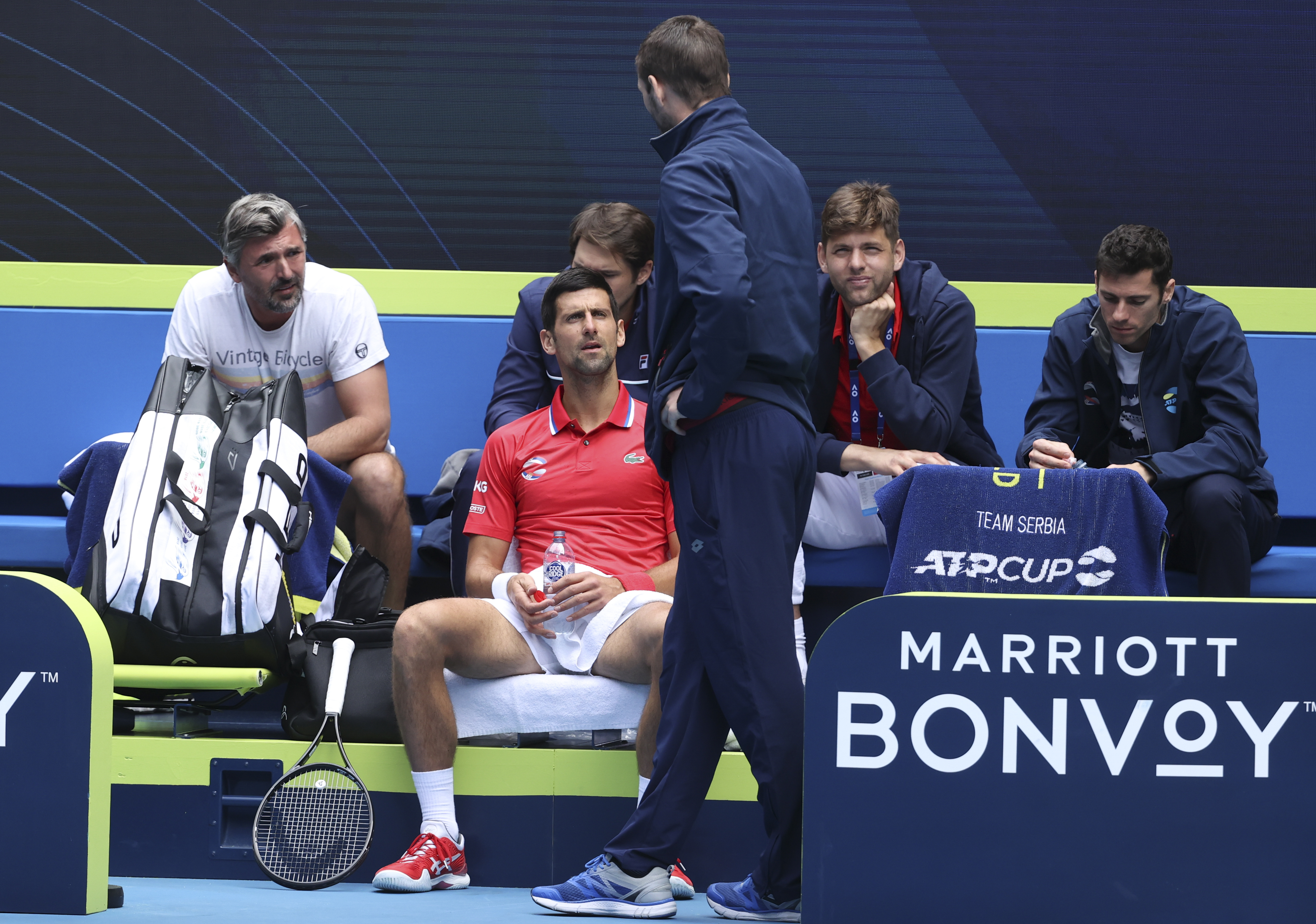 Serbia's Novak Djokovic sits with teammates during break in his match against Canada's Denis Shapovalov at the ATP Cup match in Melbourne, Australia, Tuesday, Feb. 2, 2021. (AP Photo/Hamish Blair)