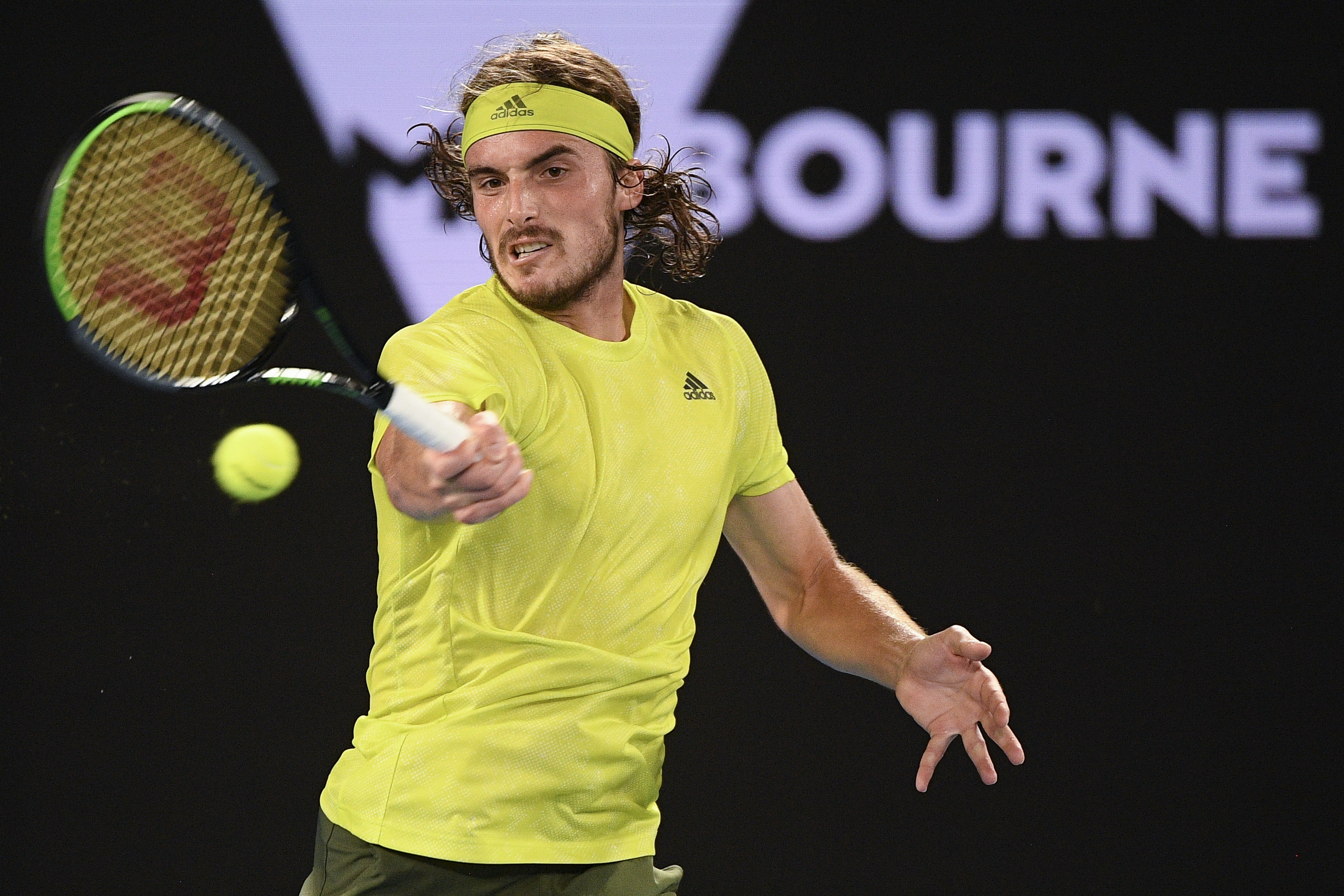 Greece's Stefanos Tsitsipas makes a forehand return to France's Gilles Simon during their first round match at the Australian Open tennis championship in Melbourne, Australia, Tuesday, Feb. 9, 2021. (AP Photo/Andy Brownbill)