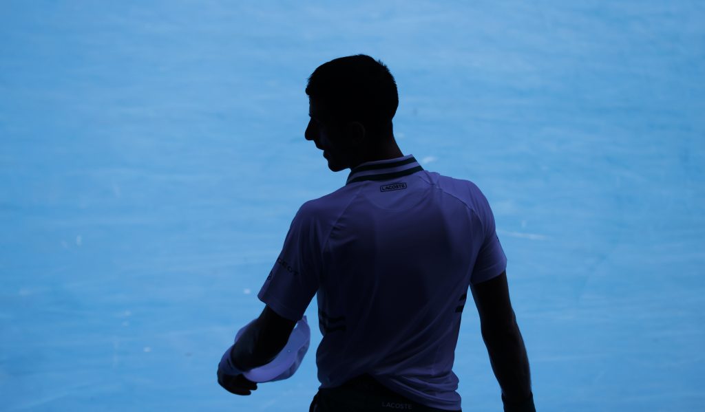Serbia's Novak Djokovic waits in the shade during his second round match against United States' Frances Tiafoe at the Australian Open tennis championship in Melbourne, Australia, Wednesday, Feb. 10, 2021.(AP Photo/Rick Rycroft)