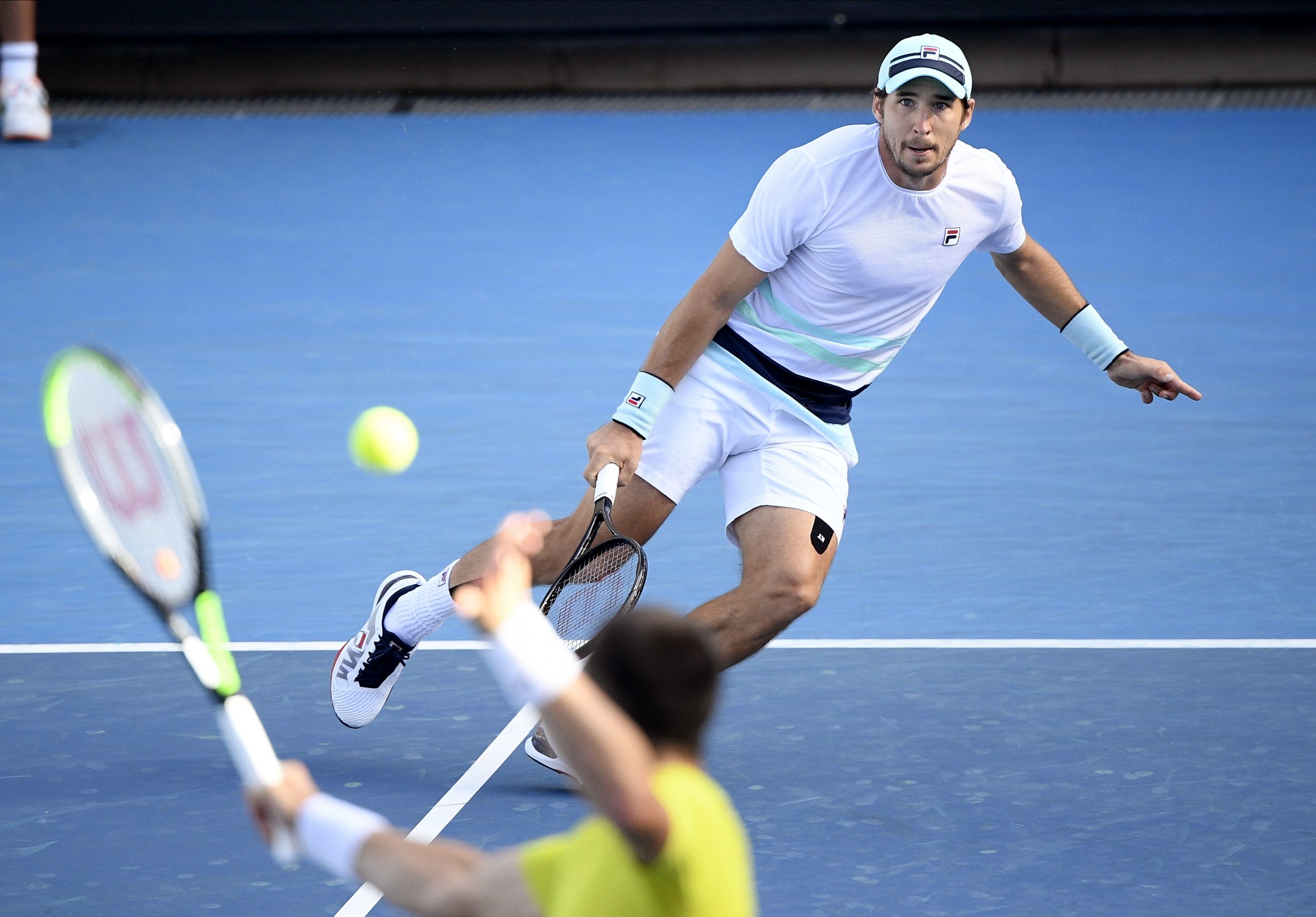 Serbia's Dusan Lajovic, right, runs to return a shot from Spain's Pedro Martinez during their third round match at the Australian Open tennis championship in Melbourne, Australia, Friday, Feb. 12, 2021.(AP Photo/Andy Brownbill)