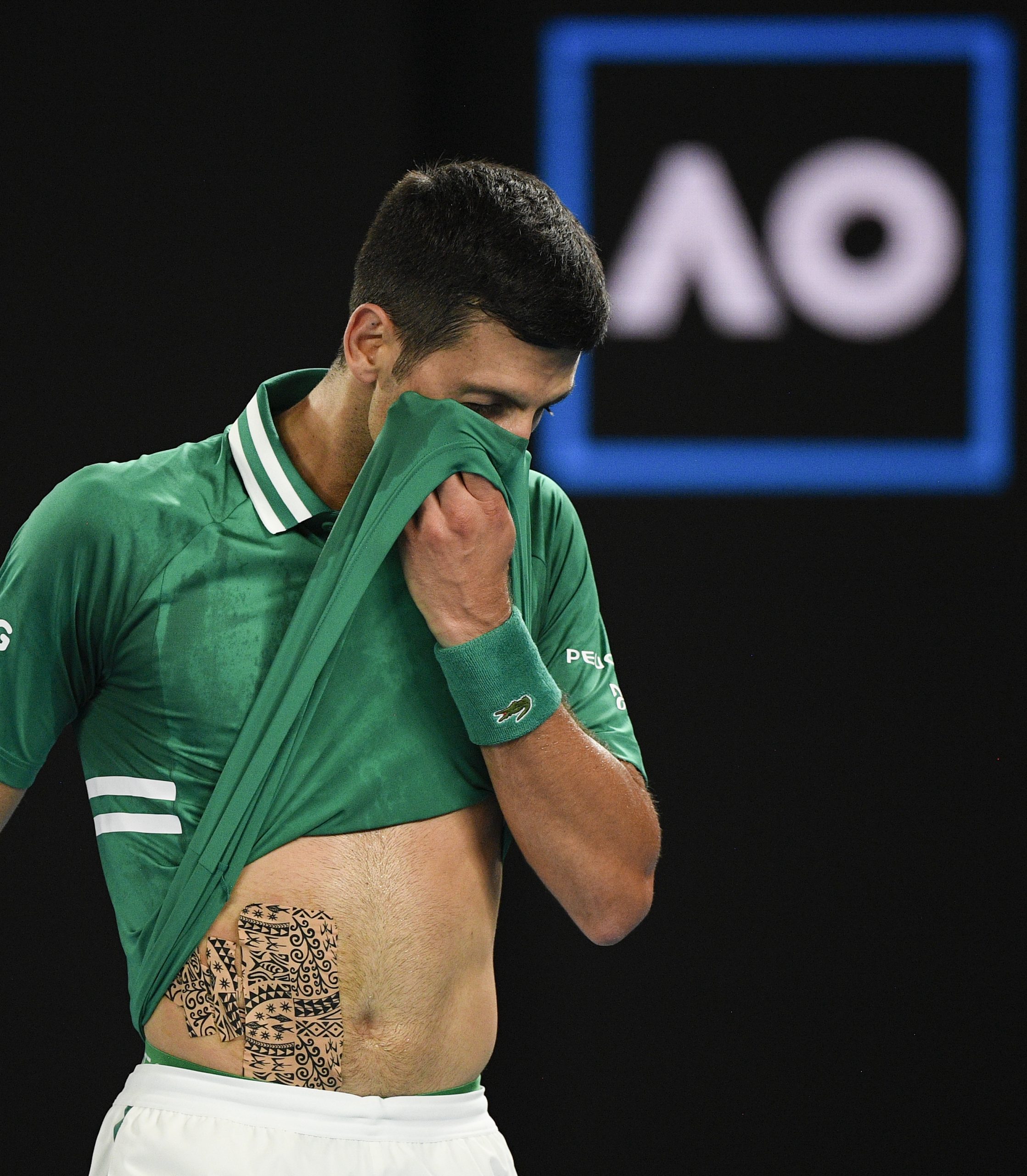 Serbia's Novak Djokovic wipes the sweat from his face during his quarterfinal match against Germany's Alexander Zverev at the Australian Open tennis championship in Melbourne, Australia, Tuesday, Feb. 16, 2021.(AP Photo/Andy Brownbill)