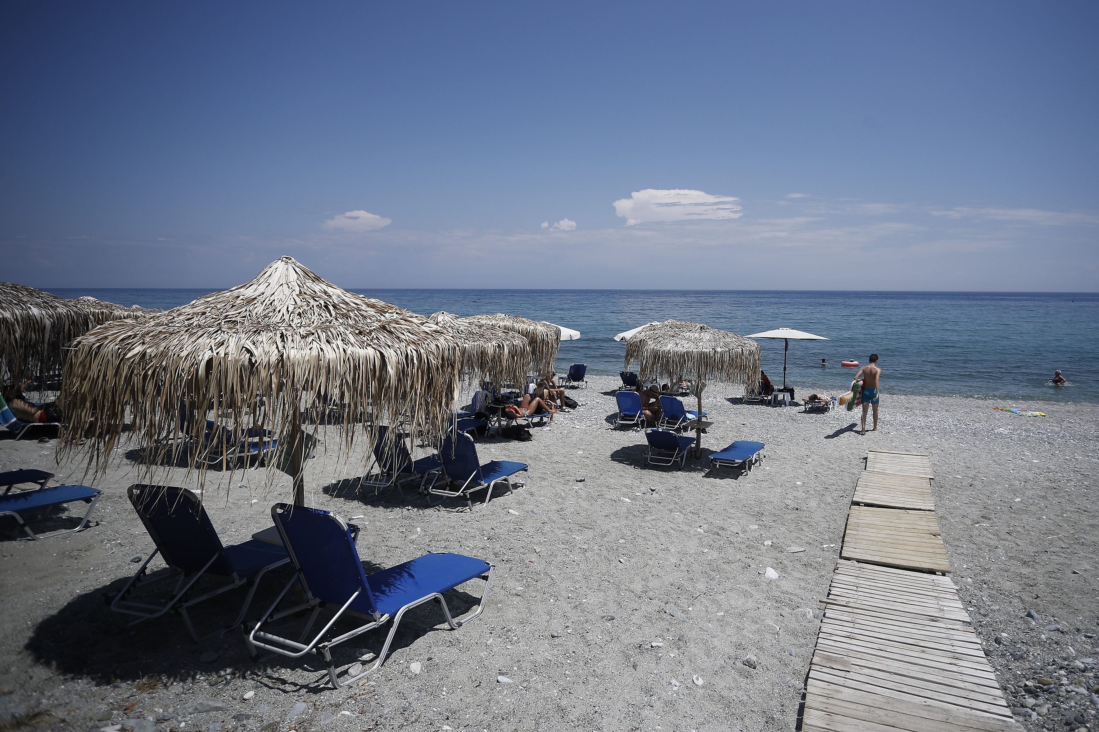 Empty sunbeds and few tourists on the beach of Leptokarya, Greece