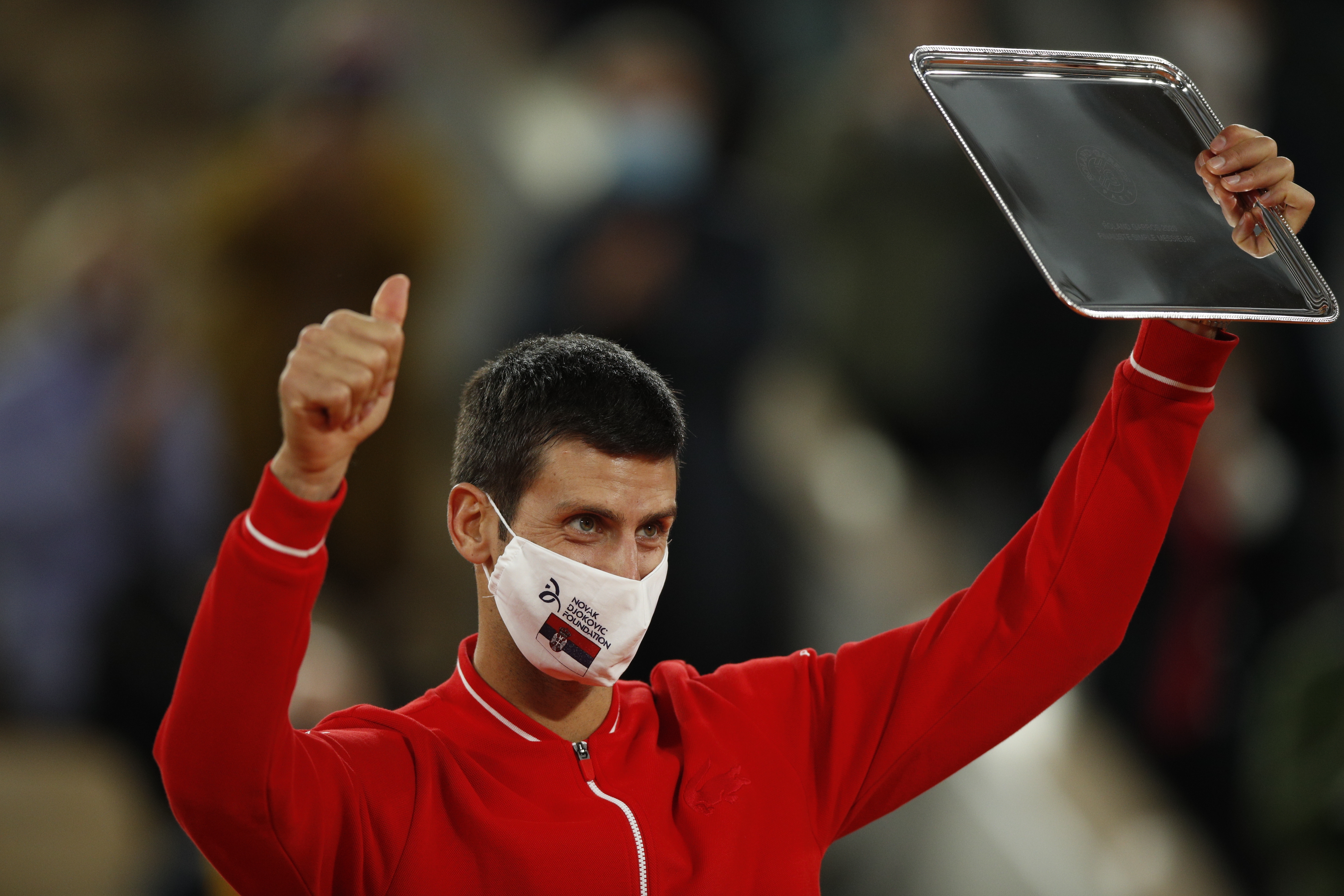 epa08736022 Novak Djokovic of Serbia holds his runner-up trophy after losing against Rafael Nadal of Spain in their men?s final match during the French Open tennis tournament at Roland ?Garros in Paris, France, 11 October 2020.  EPA-EFE/YOAN VALAT