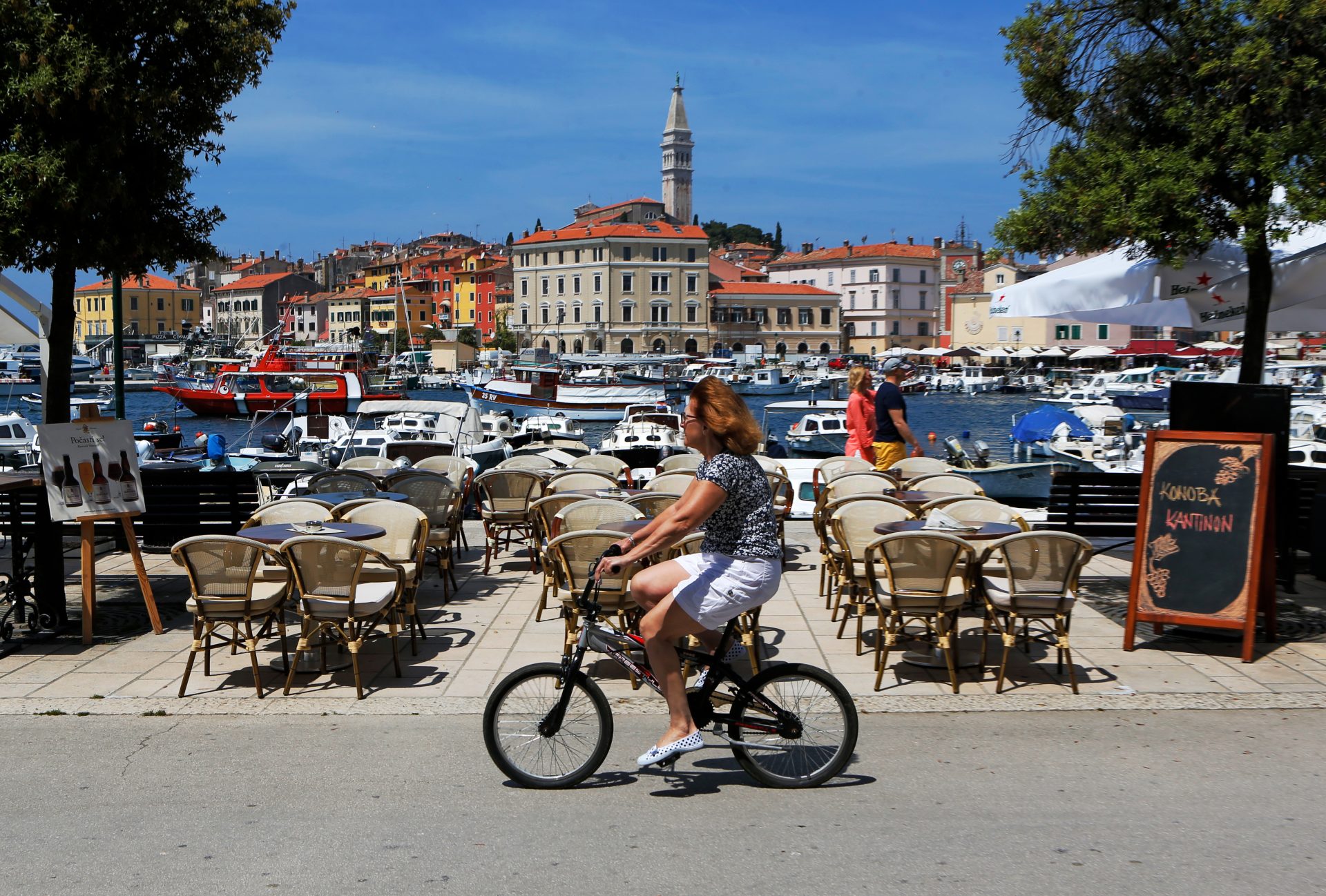 epa04758015 A tourist rides a bicycle next ot he sea in the town of Rovinj, Croatia, 20 May 2015. Rovinj is one of Croatia's most visited and important tourist destinations for the country which relies heavily on the tourist industry.  EPA/ANTONIO BAT