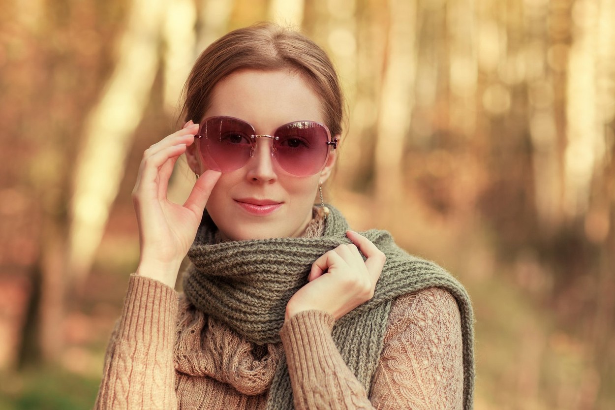 Young woman outdoors autumn fashion portrait with scarf and sunglasses