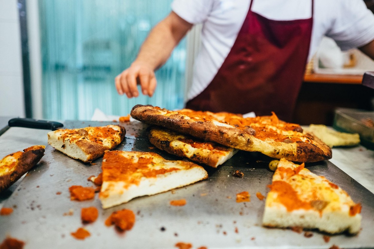 Freshly baked foccaccia Pugliese being cut and sold in Bari Vecchia, Puglia, Italy