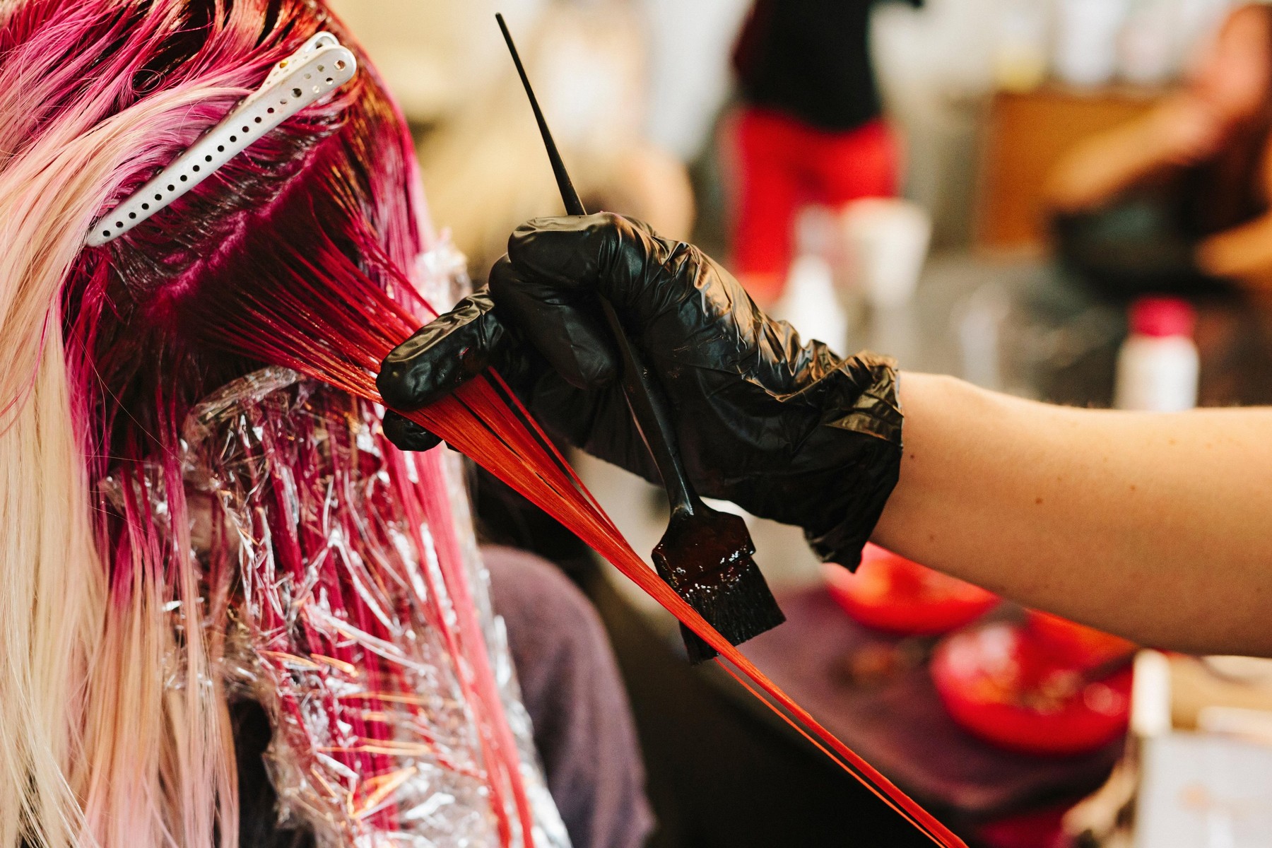 A hair colourist applying pink hair colour to a client's long blonde hair.,Image: 312192449, License: Royalty-free, Restrictions: , Model Release: yes, Credit line: Mint Images Limited / Alamy / Alamy / Profimedia