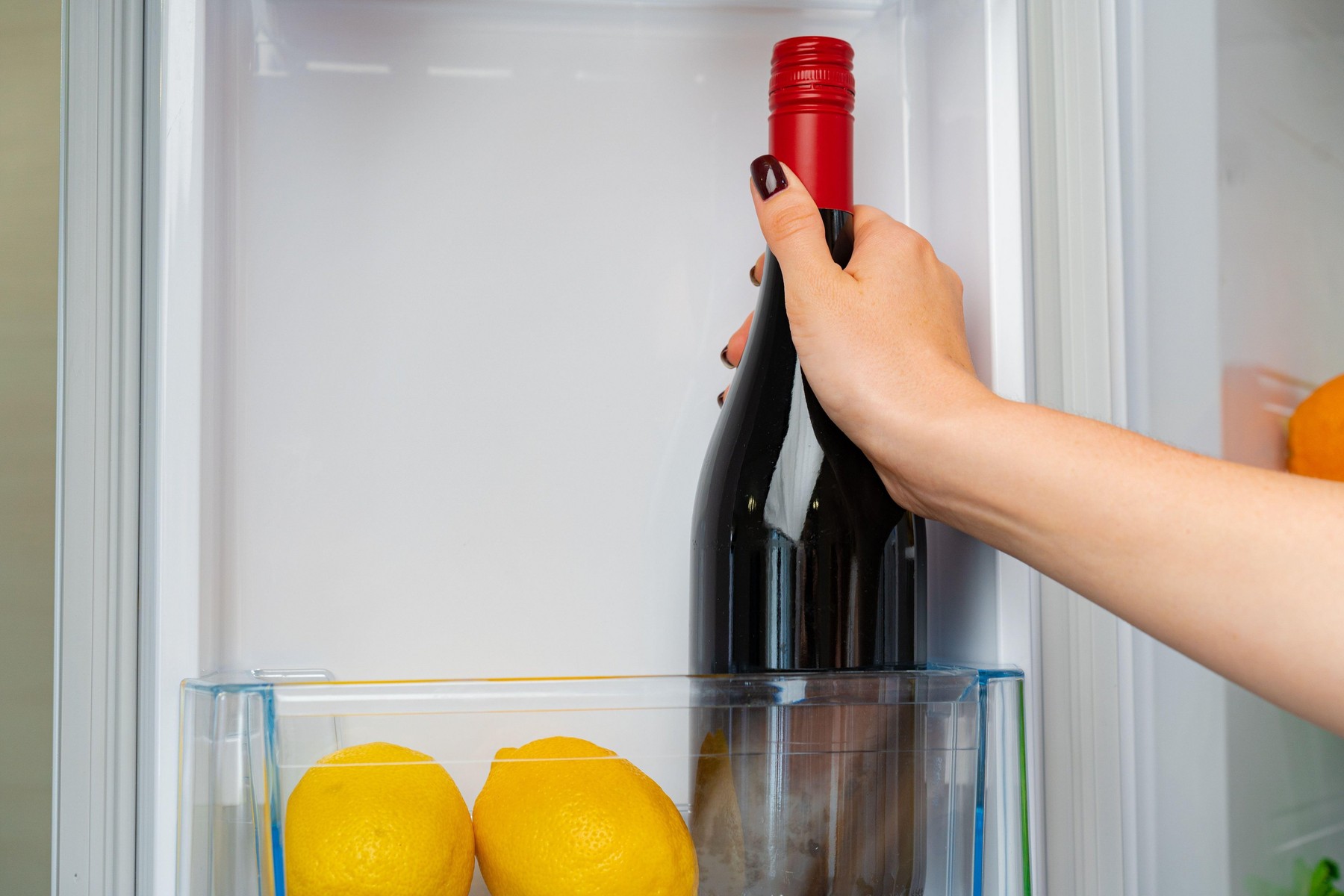 Female hand taking bottle of wine from a fridge close up,Image: 580415512, License: Royalty-free, Restrictions: , Model Release: no, Credit line: Sergey Tolmachev / Alamy / Alamy / Profimedia