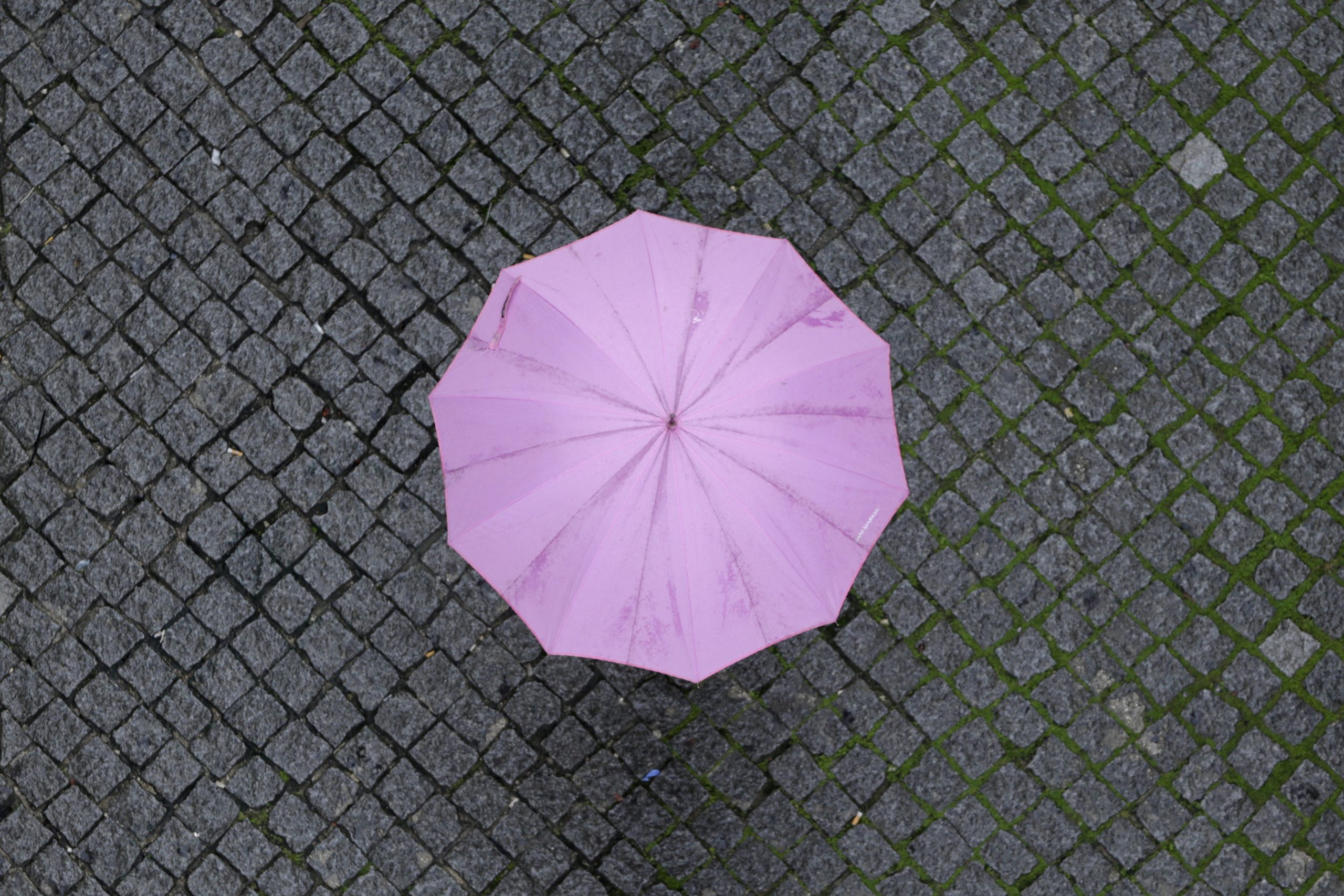 A pedestrian walks under an umbrella in a light rain in downtown Lisbon, Monday, Nov. 9, 2020. (AP Photo/Armando Franca)