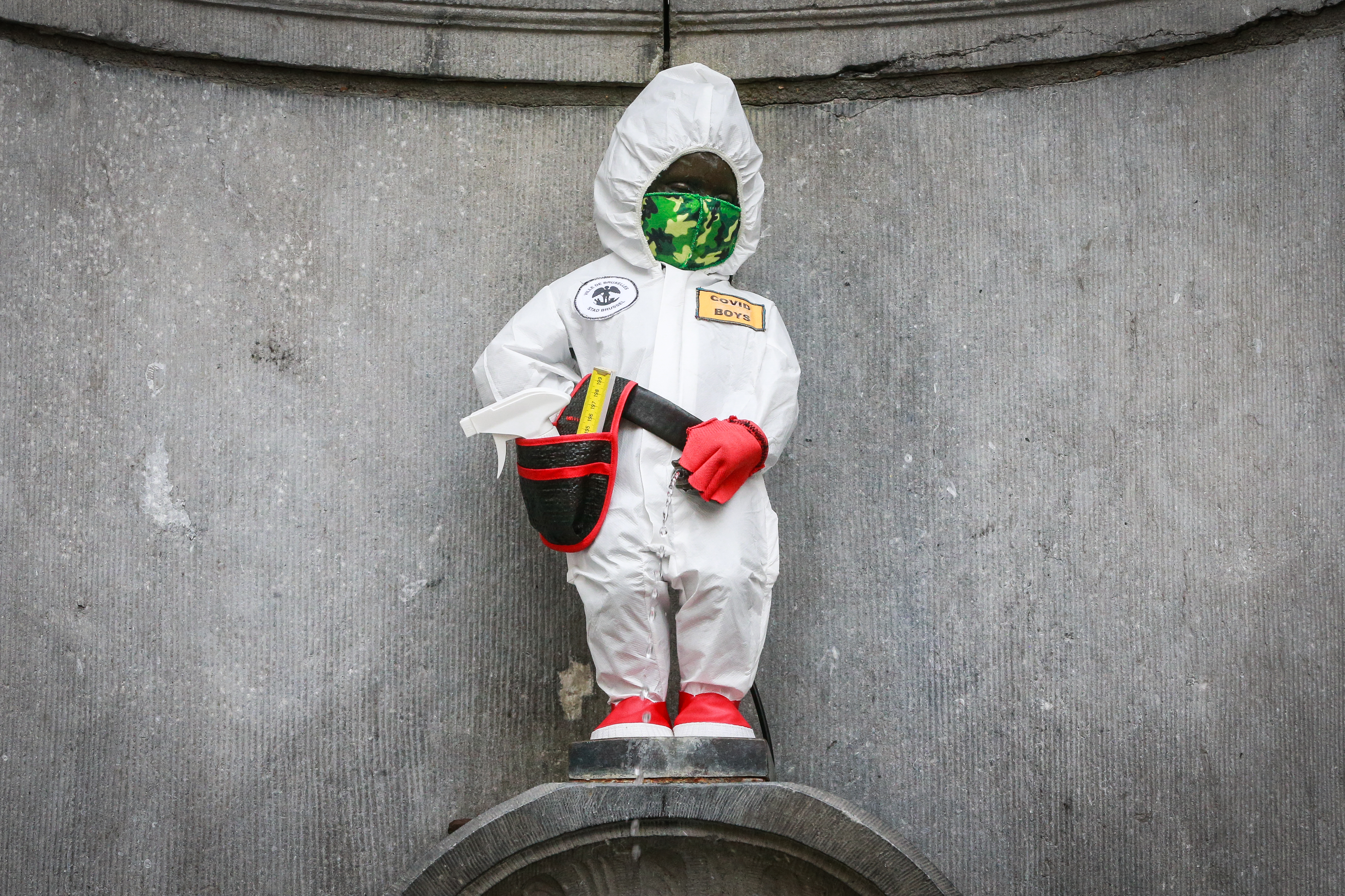 epa09081287 Manneken Pis in costume of "Covid Boys" created in collaboration with the group ''covid Boys'' and the artist Lucas Engels in Brussels, Belgium, 18 March 2021.  EPA-EFE/STEPHANIE LECOCQ