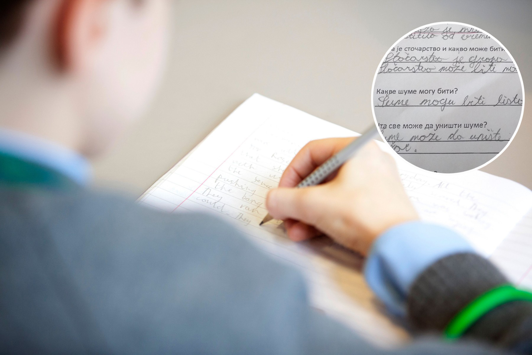 primary school boy writing in exercise book