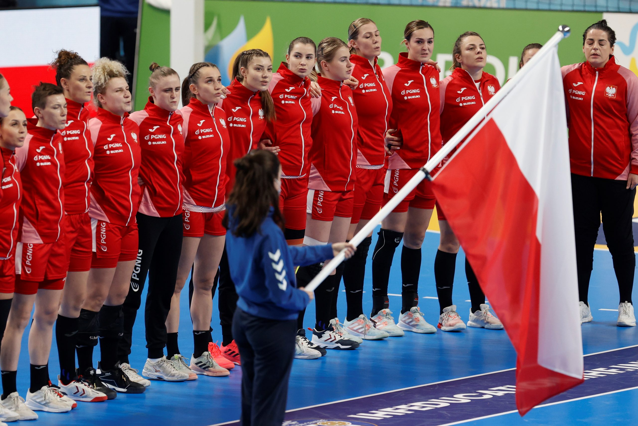 epa09619637 Players of Poland listen to their national anthem ahead of the preliminary round group B match between Serbia and Poland at the 2021 World Women's Handball Championship in Lliria, eastern Spain, 03 December 2021.  EPA-EFE/Kai Foersterling