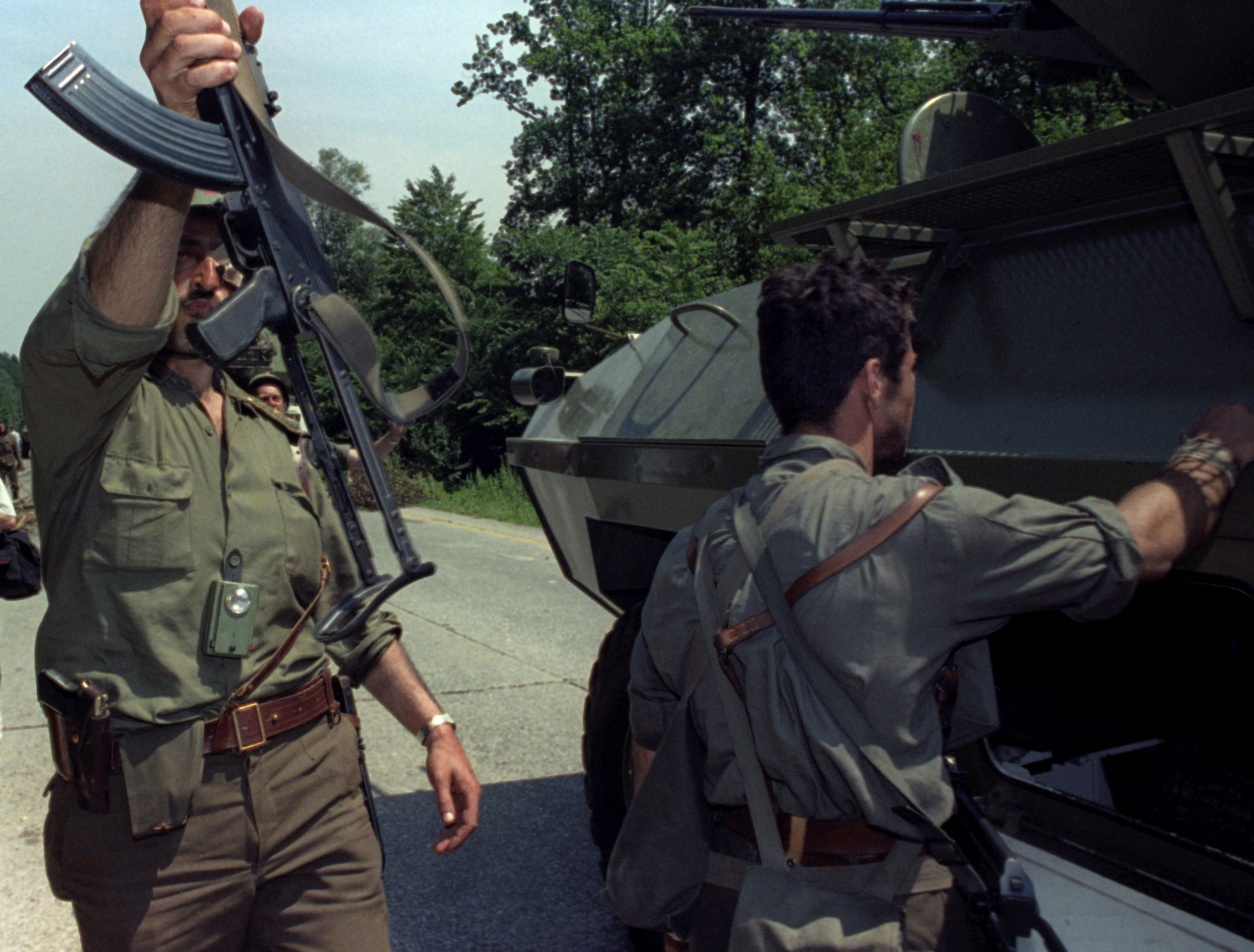 A Yugoslav Federal army soldier waves his machine gun, as the column stopped at the mine on the road, Sentilji, Slovenia, Yugoslavia, 02 July 1991. EPA/PETER NORTHALL