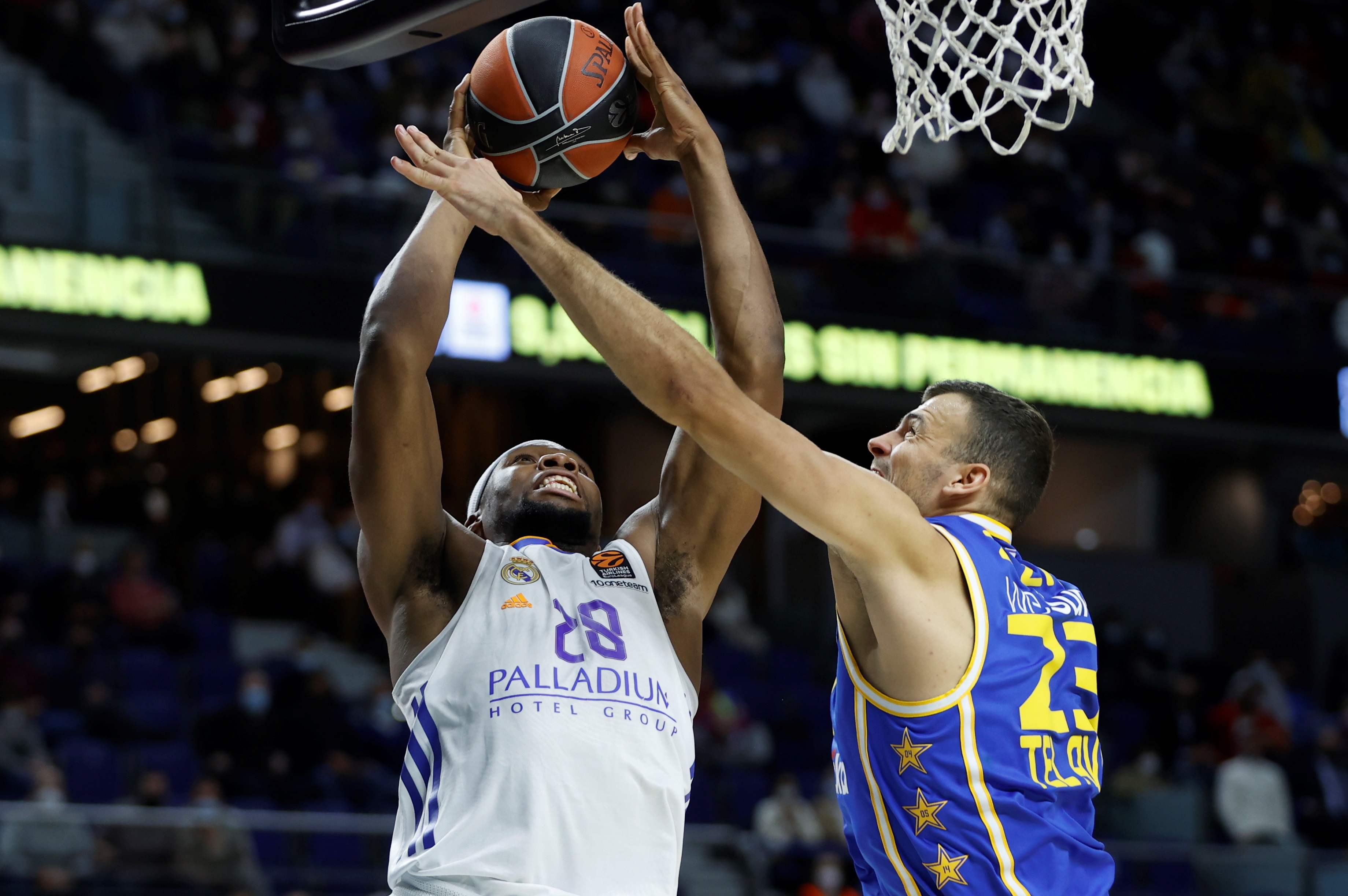 epa09617705 Real Madrid's Guerschon Yabusele (L) scores the winning basket during the Euroleague basketball game between Real Madrid and Maccabi Playtika Tel Aviv in Madrid, Spain, 02 December 2021.  EPA-EFE/MARISCAL