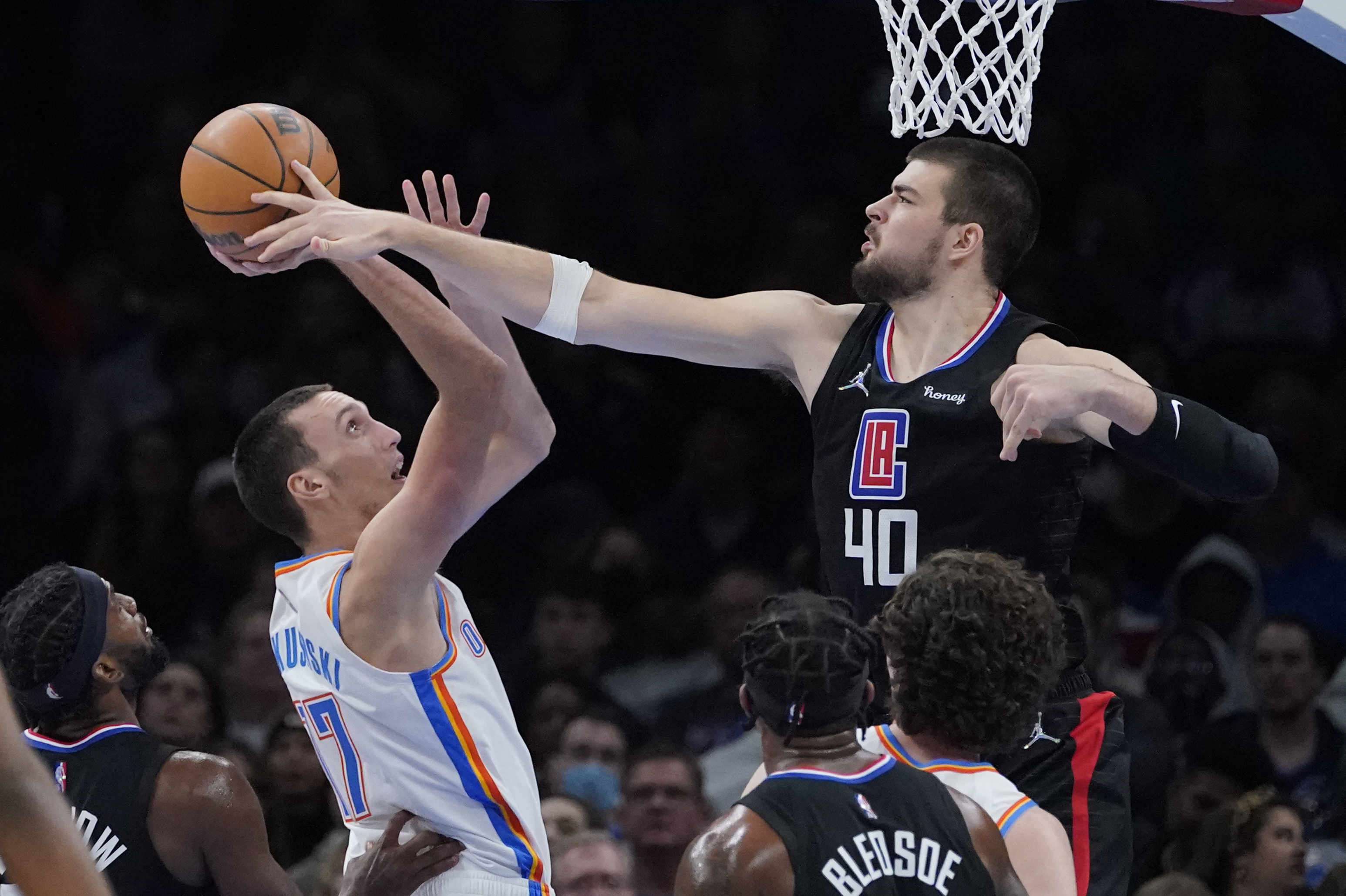 Oklahoma City Thunder center Aleksej Pokusevski (17) is fouled by Los Angeles Clippers center Ivica Zubac (40) in the second half of an NBA basketball game, Saturday, Dec. 18, 2021, in Oklahoma City. (AP Photo/Sue Ogrocki)