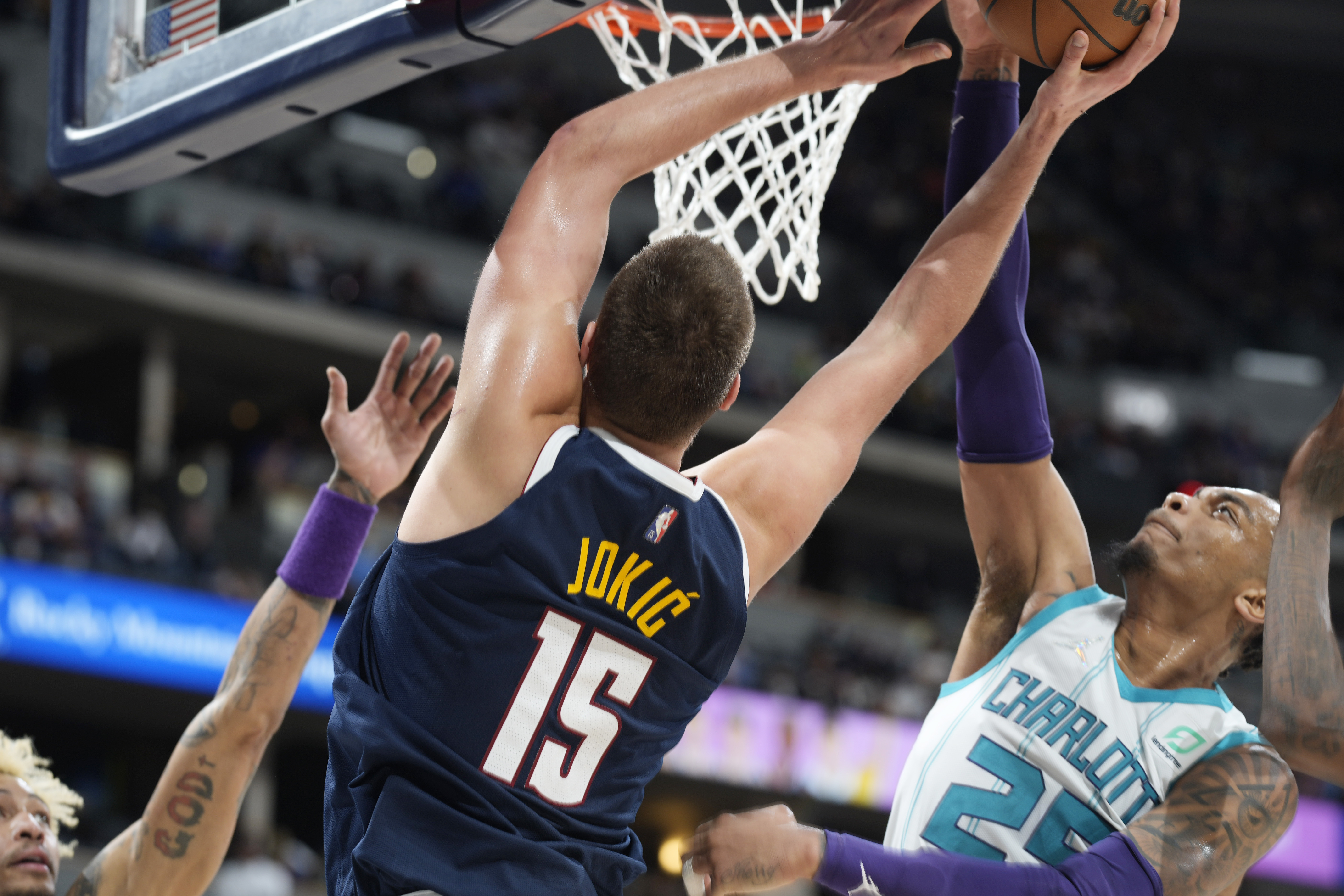 Charlotte Hornets forward P.J. Washington, right, blocks a shot by Denver Nuggets center Nikola Jokic during the second half of an NBA basketball game Thursday, Dec. 23, 2021, in Denver. The Hornets won 115-107. (AP Photo/David Zalubowski)