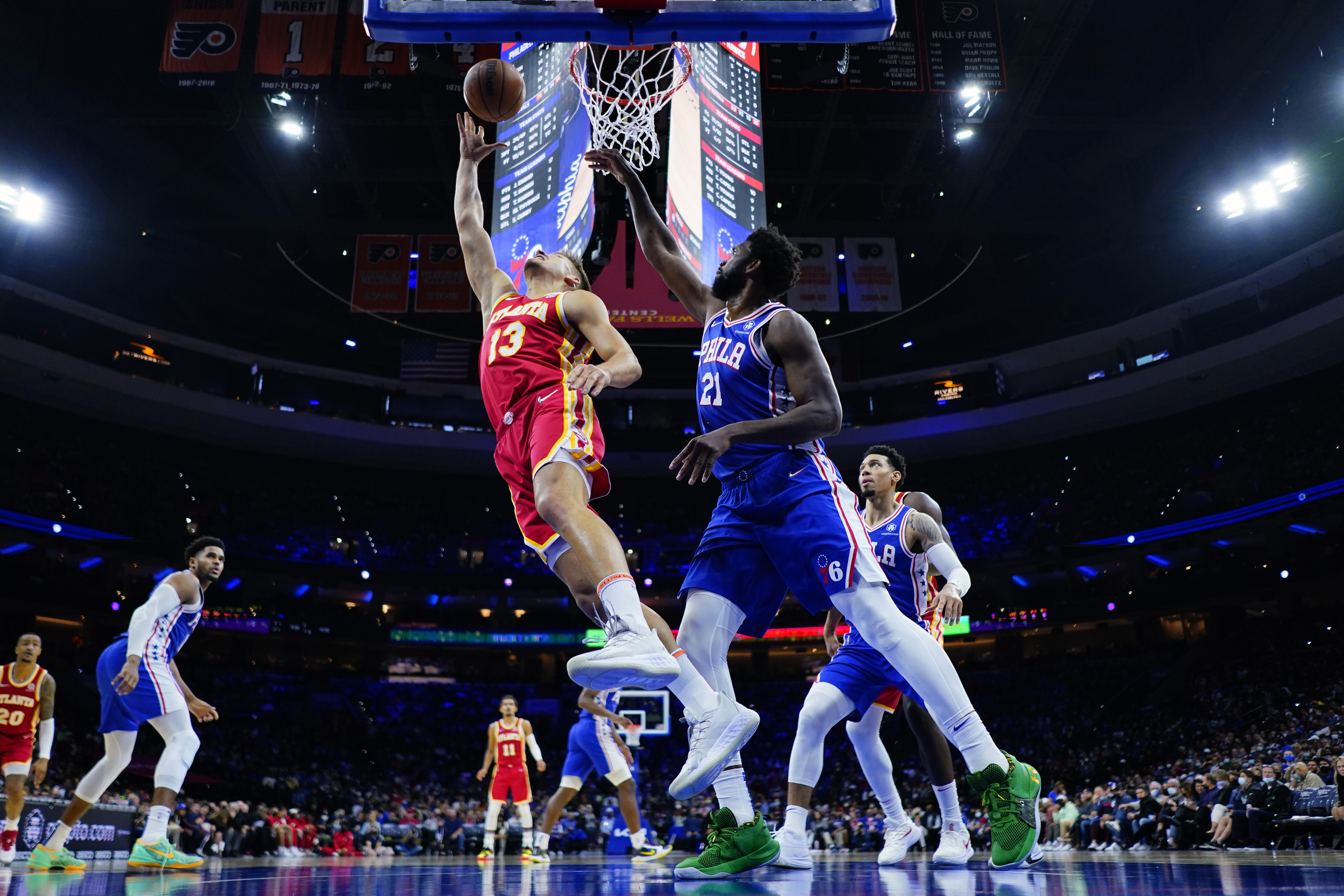 Atlanta Hawks' Bogdan Bogdanovic (13) goes up for a shot against Philadelphia 76ers' Joel Embiid (21) during the second half of an NBA basketball game, Saturday, Oct. 30, 2021, in Philadelphia. (AP Photo/Matt Slocum)