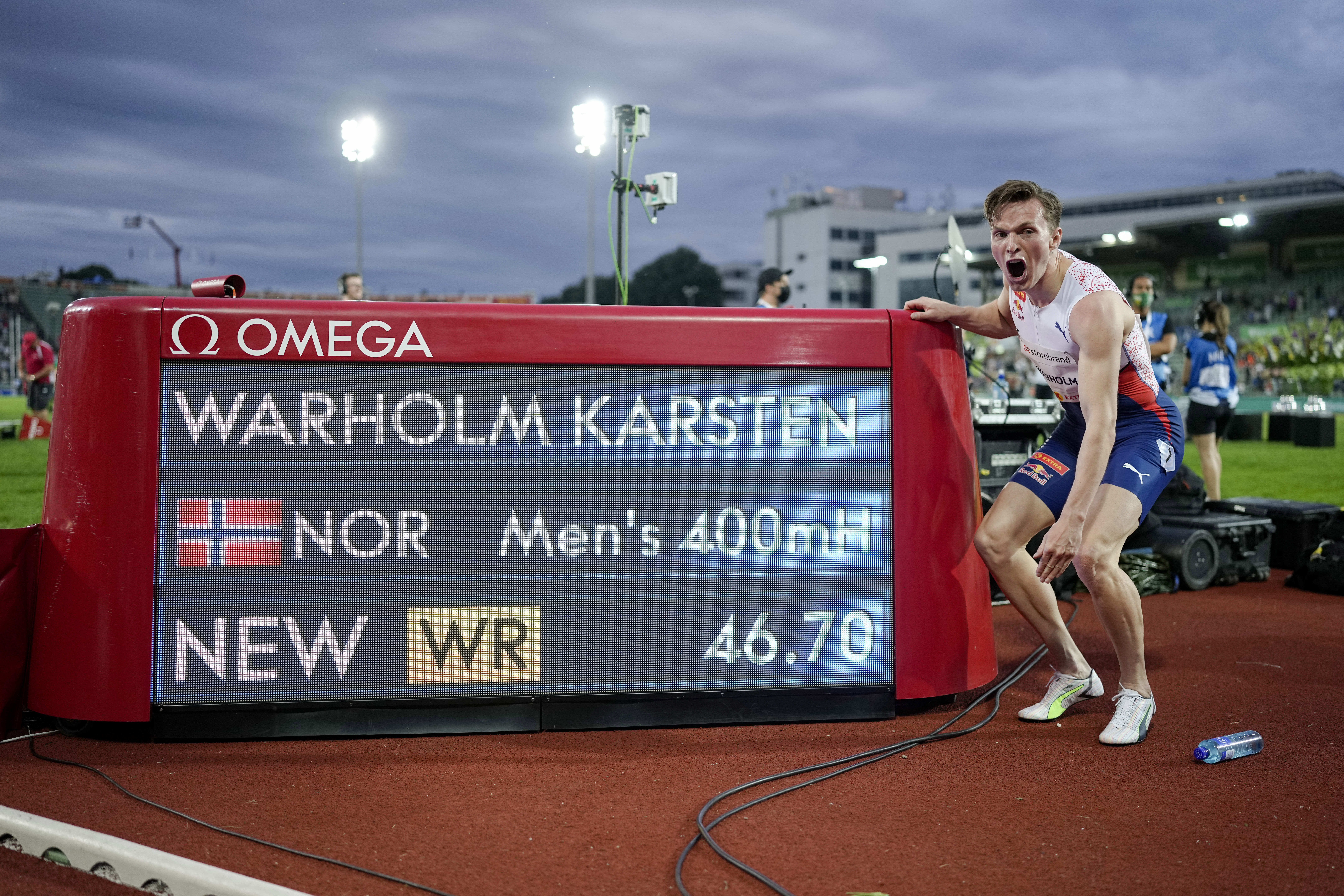 Norway's Karsten Warholm celebrates in front of the scoreboard after running 46.70 seconds to set a new men's 400m hurdles world record at the Diamond League meeting in Oslo, Norway Thursday July 1, 2021. (Fredrik Hagen, NTB via AP)