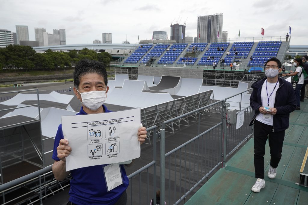 epa09205927 An escort staff shows manners to prevent the COVID-19 during the Cycling BMX Free Style of Tokyo 2020 Olympics test event at Ariake Urban Sports Park in Tokyo, Japan, 17 May 2021.  EPA-EFE/KIMIMASA MAYAMA
