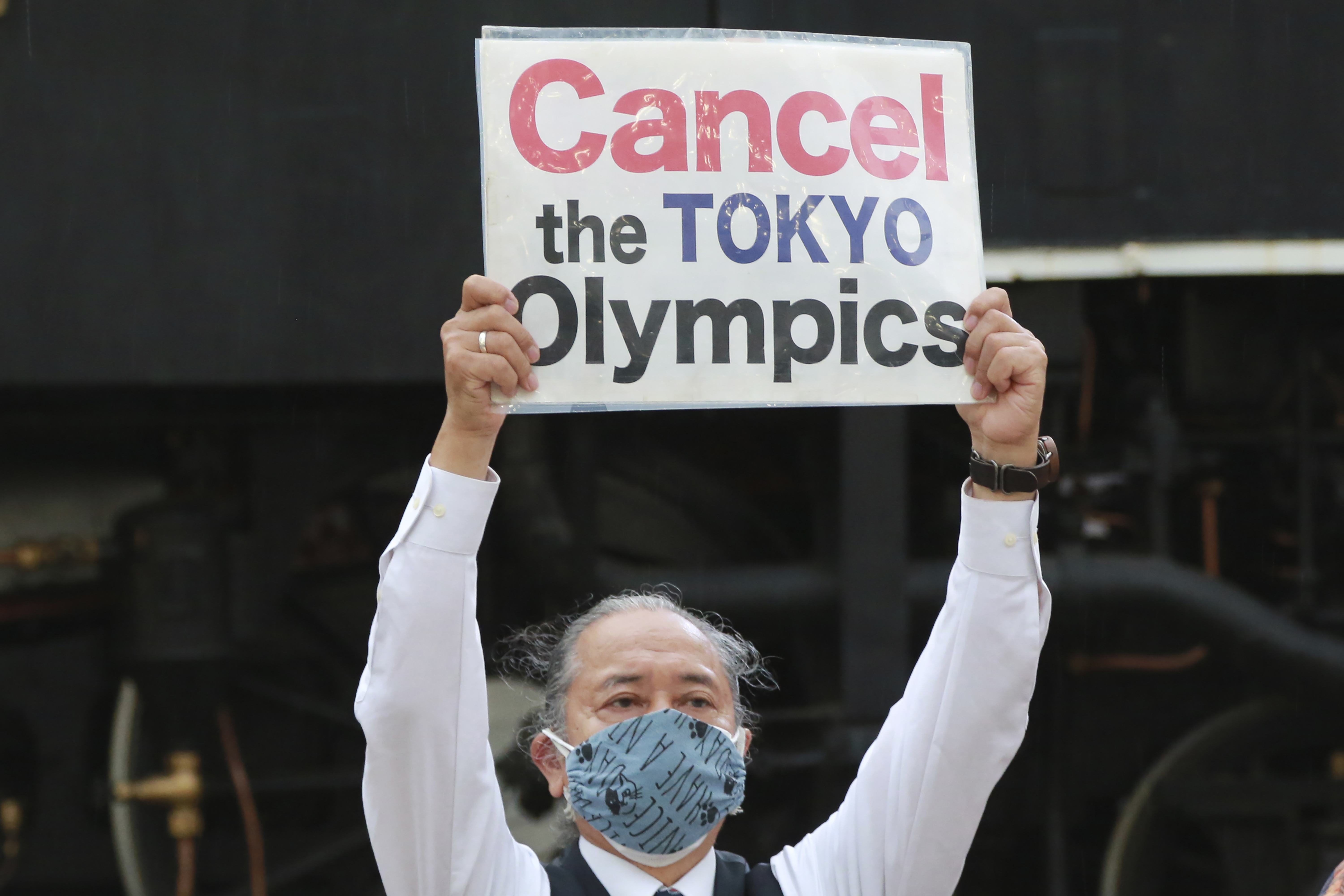 A demonstrator holding a placard during an anti-Olympics demonstration in Tokyo, Monday, May 17, 2021. (AP Photo/Koji Sasahara)
