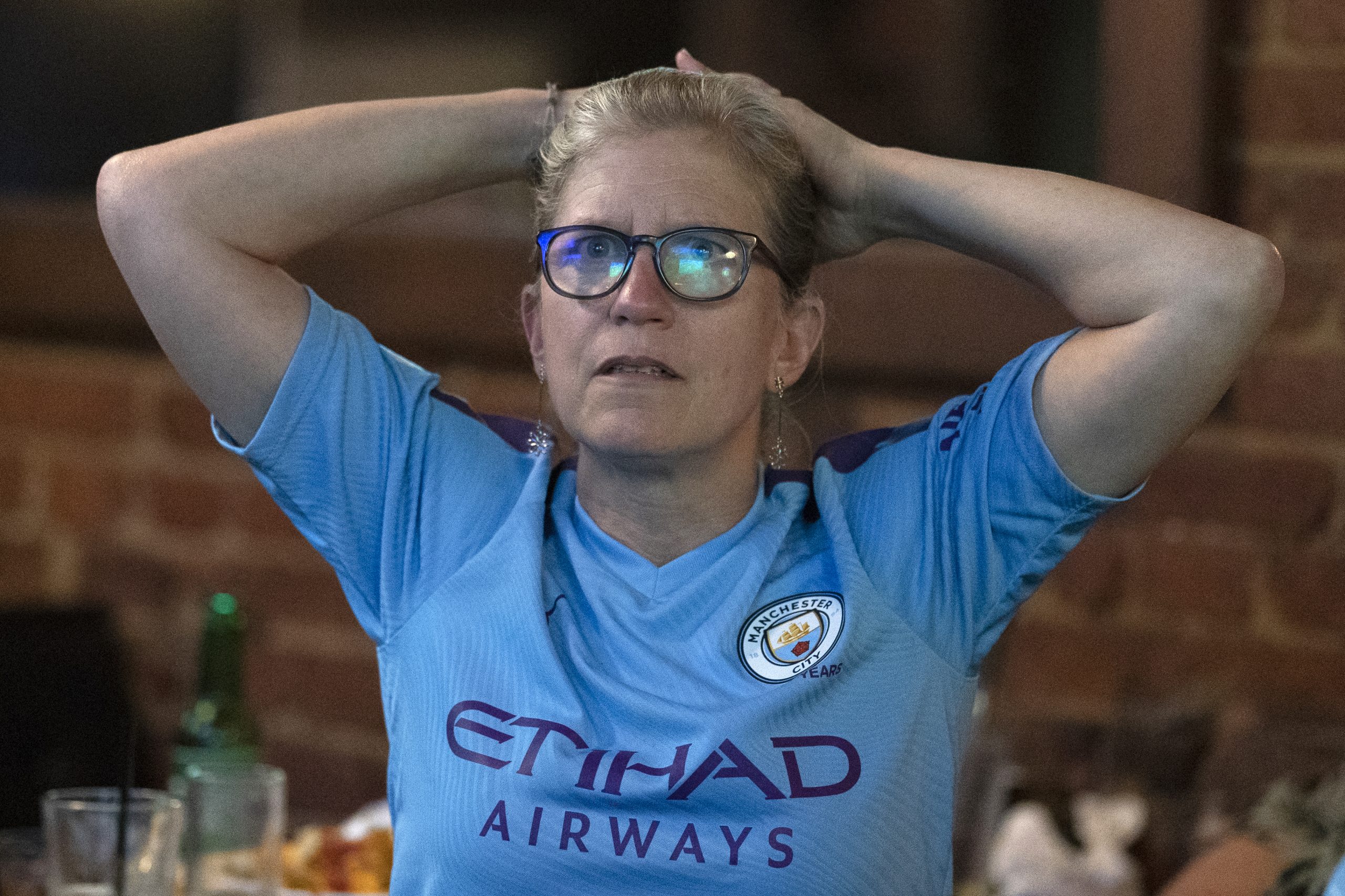 epa09235779 A Manchester City supporter watches the UEFA Champions League final in a bar in Washington DC, USA, 29 May 2021. The UEFA Champions League final between Manchester City and Chelsea FC takes place in Porto, Portugal.  EPA-EFE/WILL OLIVER