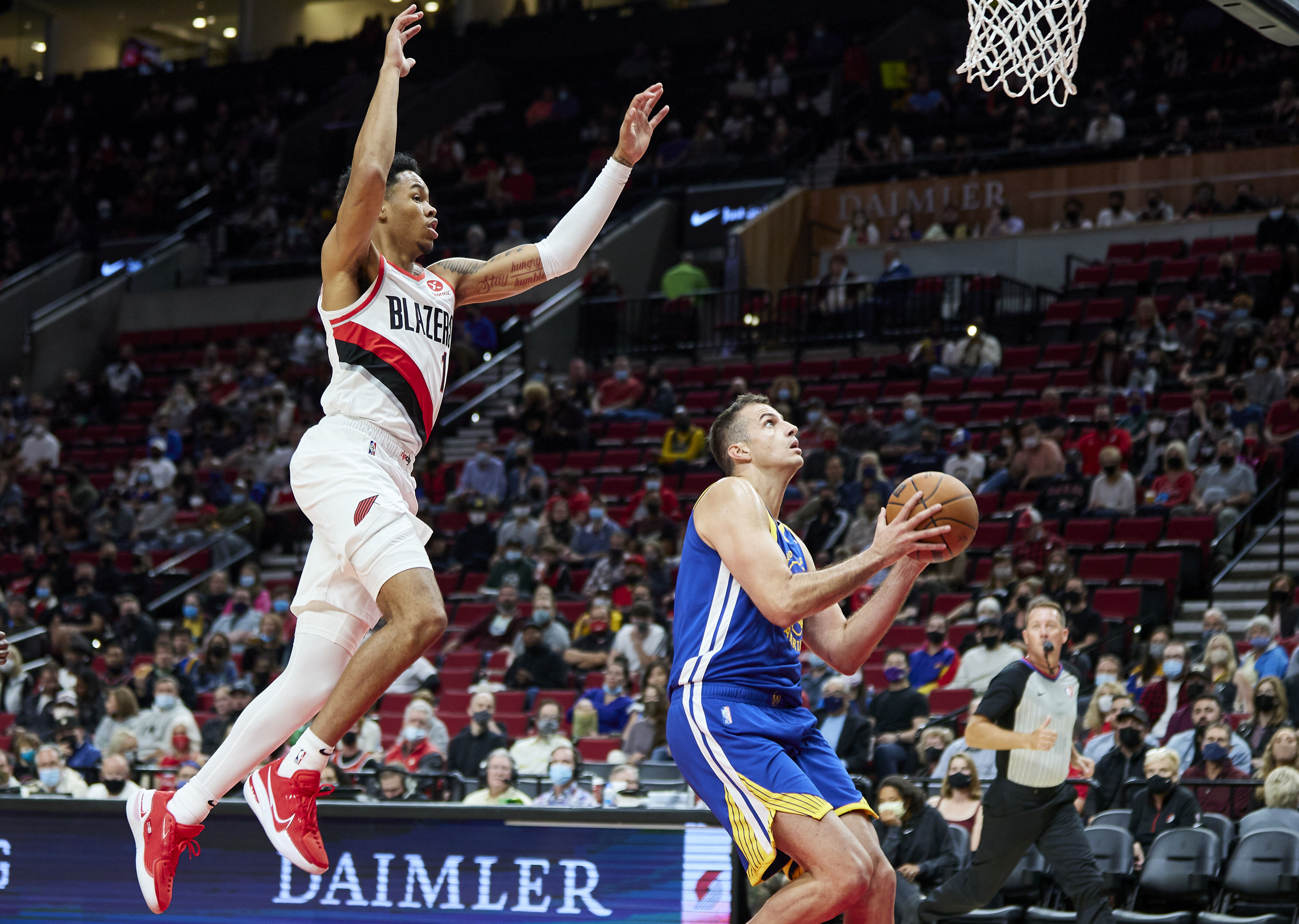 Golden State Warriors forward Nemanja Bjelica, right, shoots in front of Portland Trail Blazers guard Anfernee Simons during the first half of a preseason NBA basketball game in Portland, Ore., Monday, Oct. 4, 2021. (AP Photo/Craig Mitchelldyer)