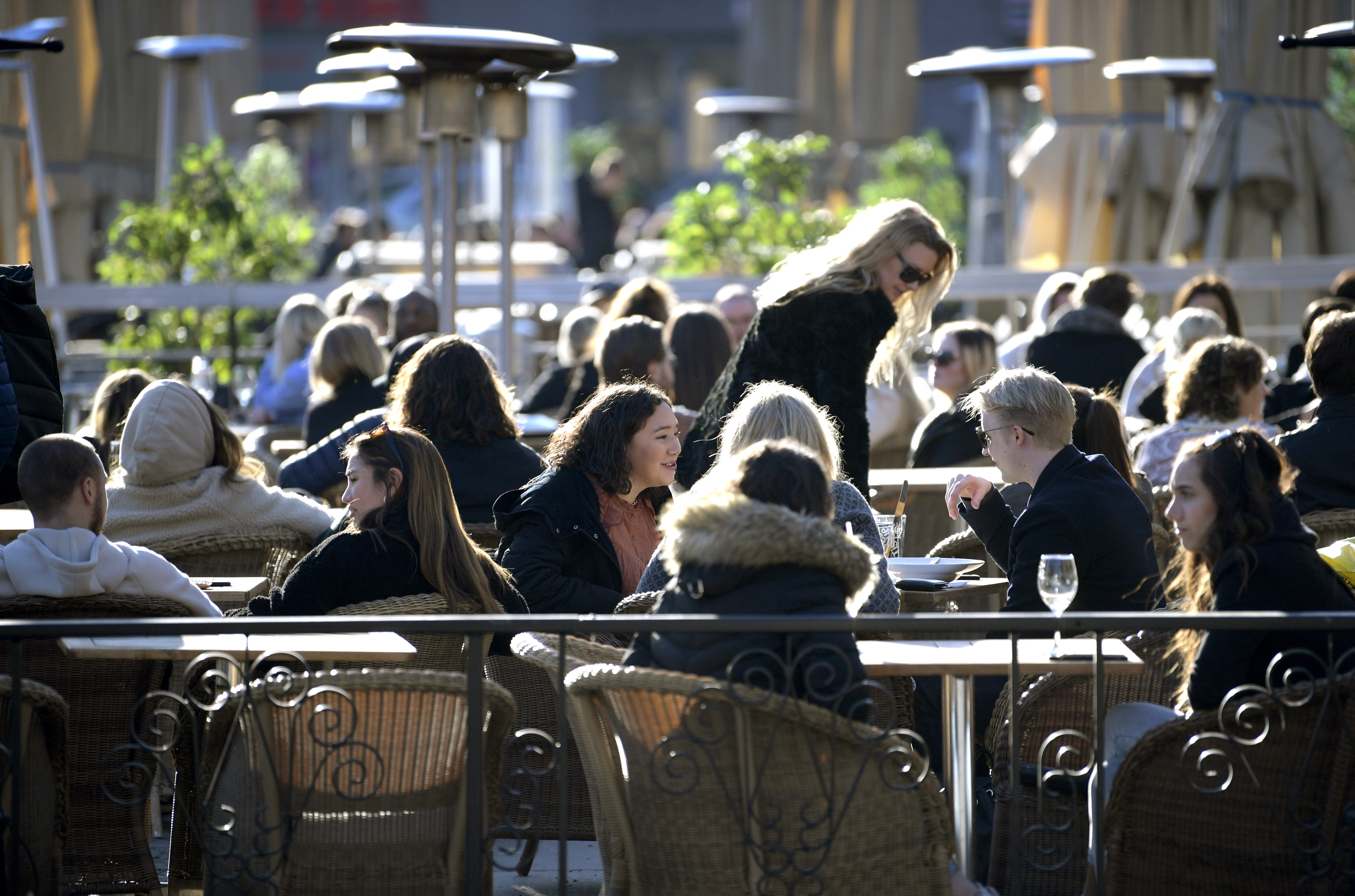 People enjoy the sun in an outdoor restaurant in Stockholm