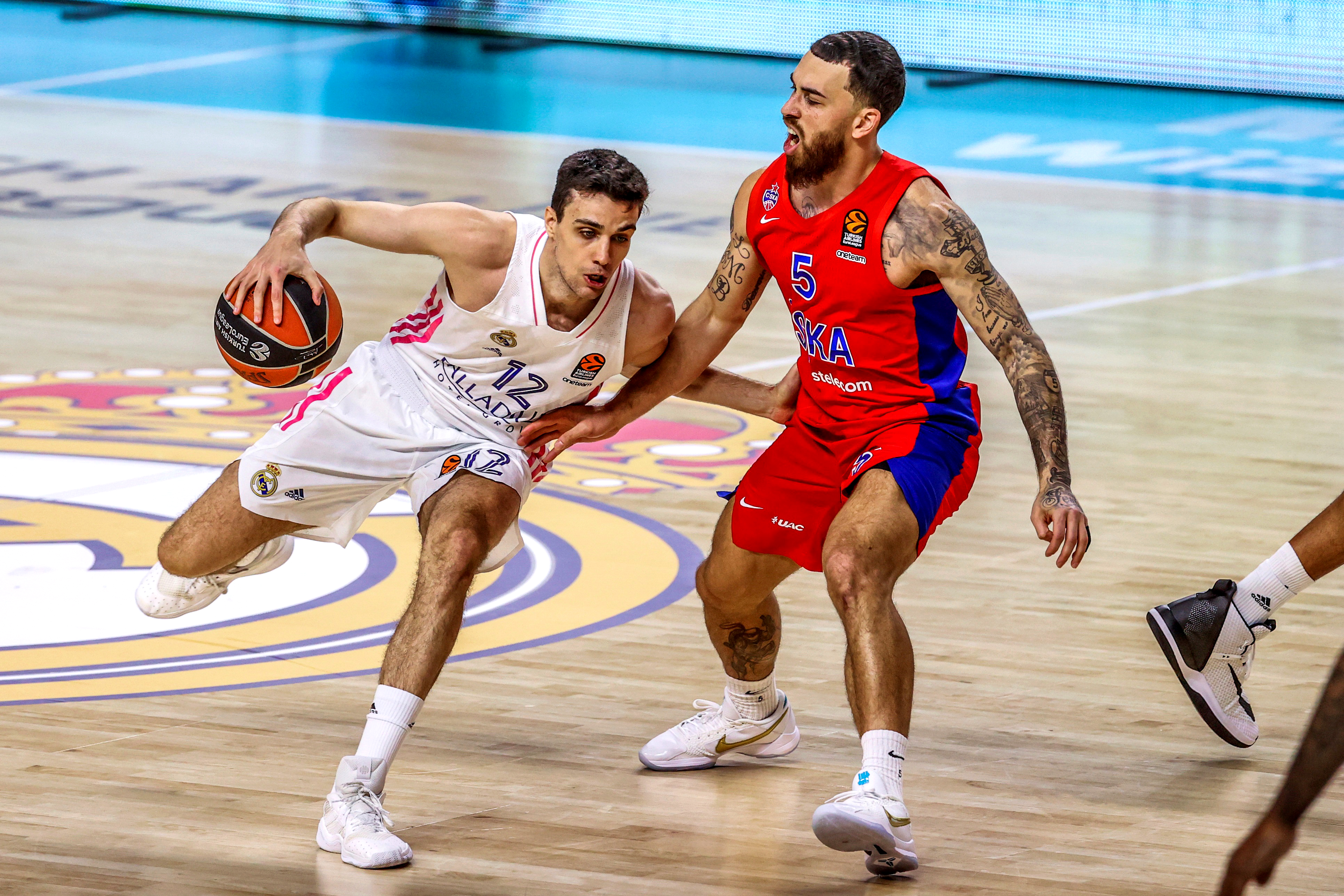 epa09082872 Real Madrid's Carlos Alocen (L) in action against CSKA Moscow's Mike James (R) during the Euroleague basketball match between Real Madrid and CSKA Moscow in Madrid, Spain, 18 March 2021.  EPA-EFE/JuanJo Martin