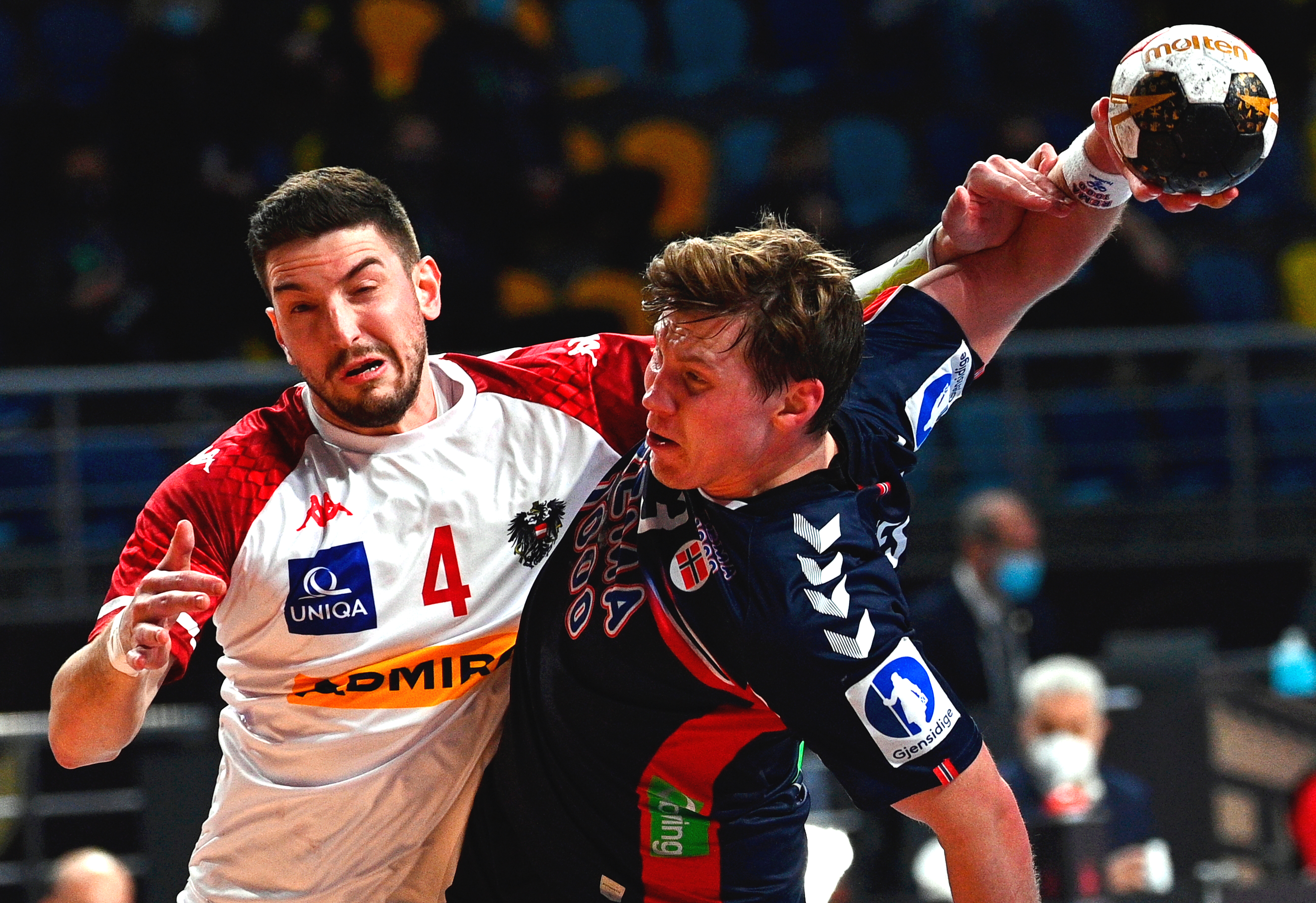 epa08947071 Norway's Goran Sogard Johannessen (R) in action against Austria's Maximilian Hermann (L) during the match between Norway and Austria at the 27th Men's Handball World Championship in Giza, Egypt, 18 January 2021.  POOL