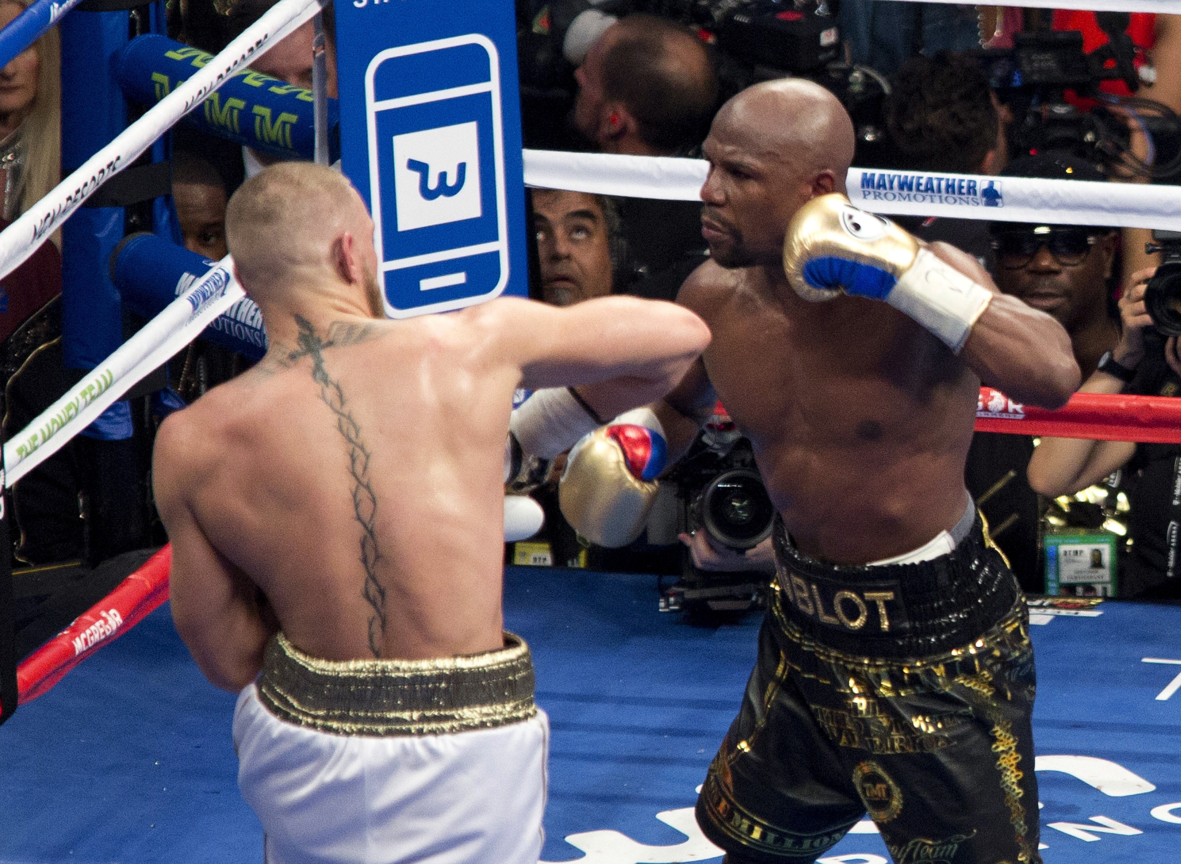epa06166246 US boxer Floyd Mayweather Jr. (R) throws a punch at Conor McGregor of Ireland during their fight for the WBC 'Money Belt' at the T-Mobile Arena in Las Vegas, Nevada, USA, 26 August 2017.  EPA-EFE/ARMANDO ARORIZO