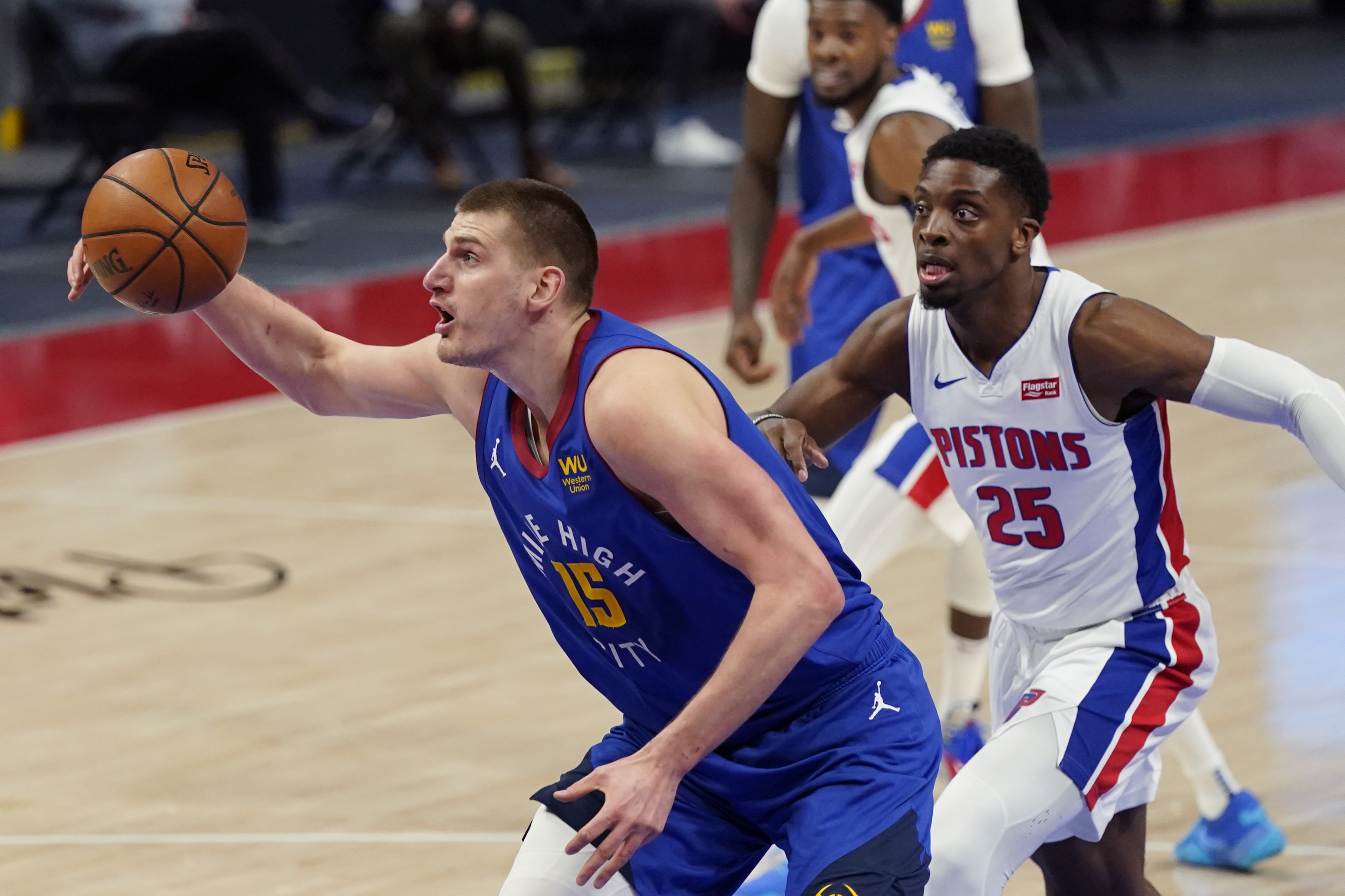Denver Nuggets center Nikola Jokic (15) grabs a rebound in front of Detroit Pistons forward Tyler Cook (25) during the first half of an NBA basketball game, Friday, May 14, 2021, in Detroit. (AP Photo/Carlos Osorio)