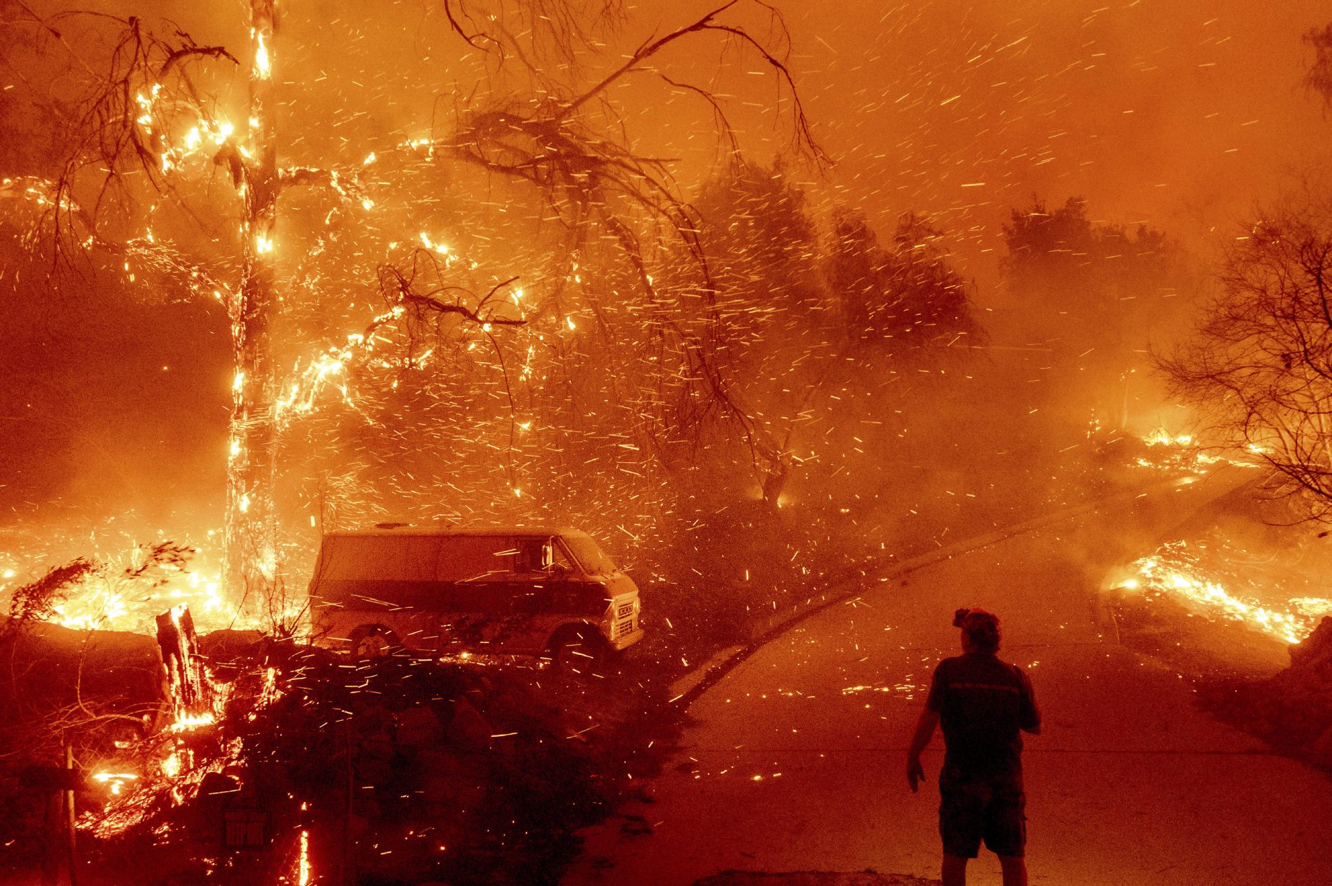 Bruce McDougal watches embers fly over his property as the Bond Fire burns through the Silverado community in Orange County, Calif., on Thursday, Dec. 3, 2020. (AP Photo/Noah Berger)