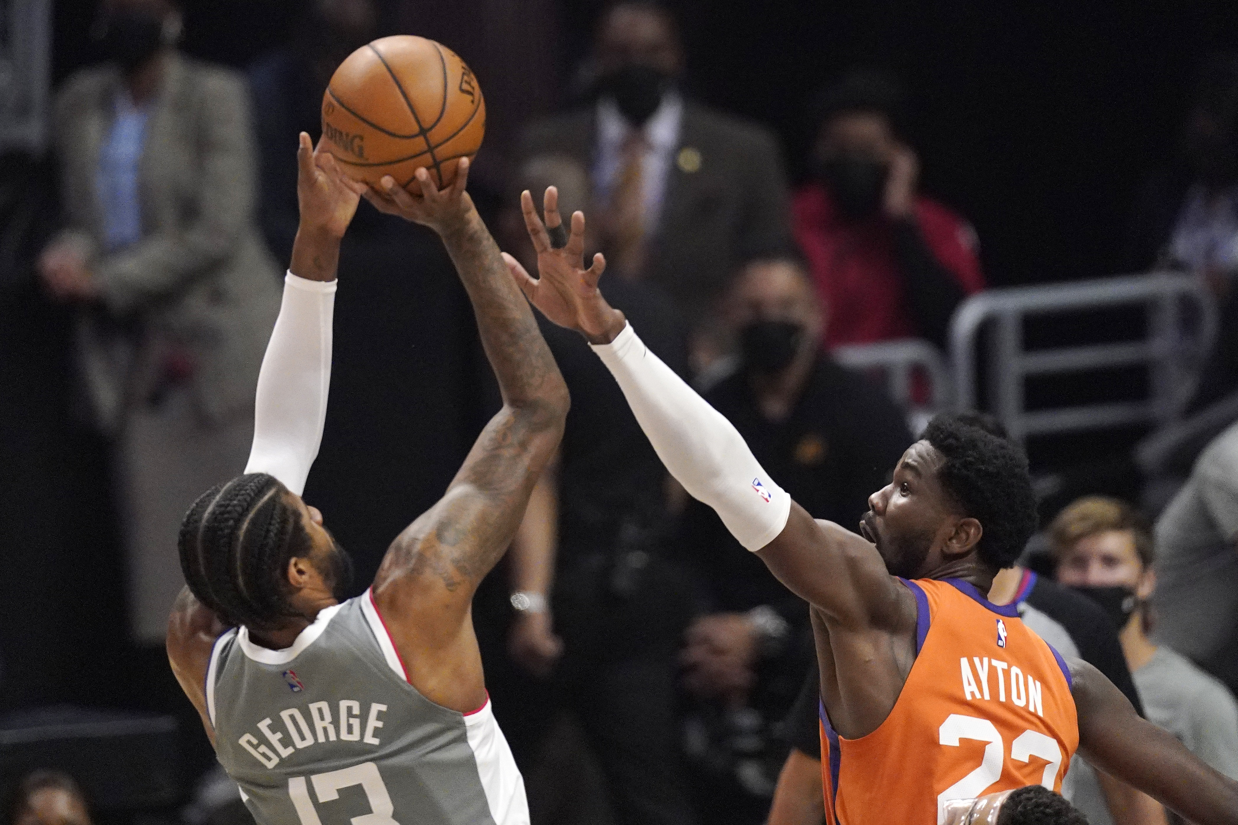 Los Angeles Clippers guard Paul George, left, shoots as Phoenix Suns center Deandre Ayton defends during the first half in Game 4 of the NBA basketball Western Conference Finals Saturday, June 26, 2021, in Los Angeles. (AP Photo/Mark J. Terrill)