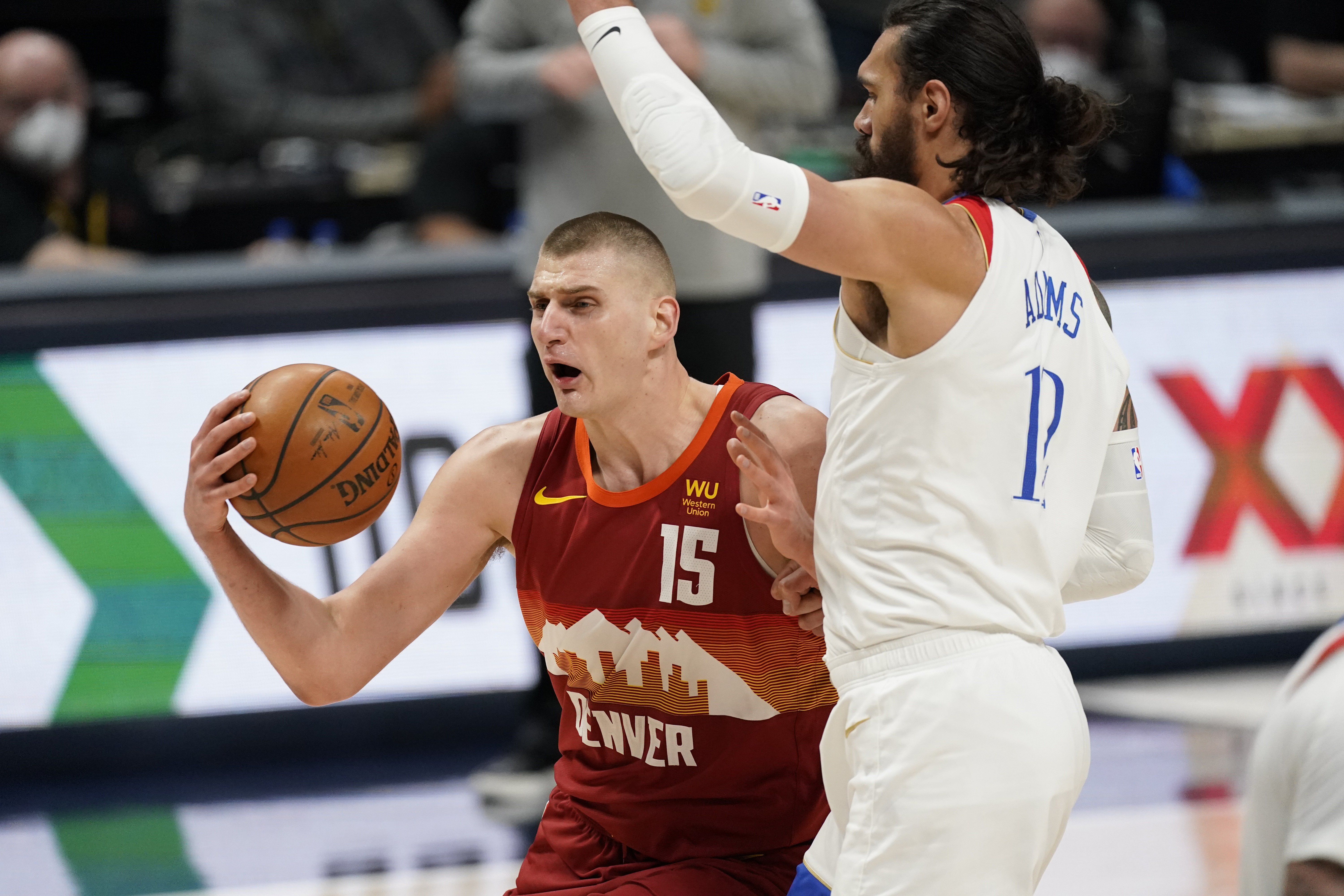 Denver Nuggets center Nikola Jokic, (15) drives to the rim as New Orleans Pelicans center Steven Adams defends in the first half of an NBA basketball game Wednesday, April 28, 2021, in Denver. (AP Photo/David Zalubowski)