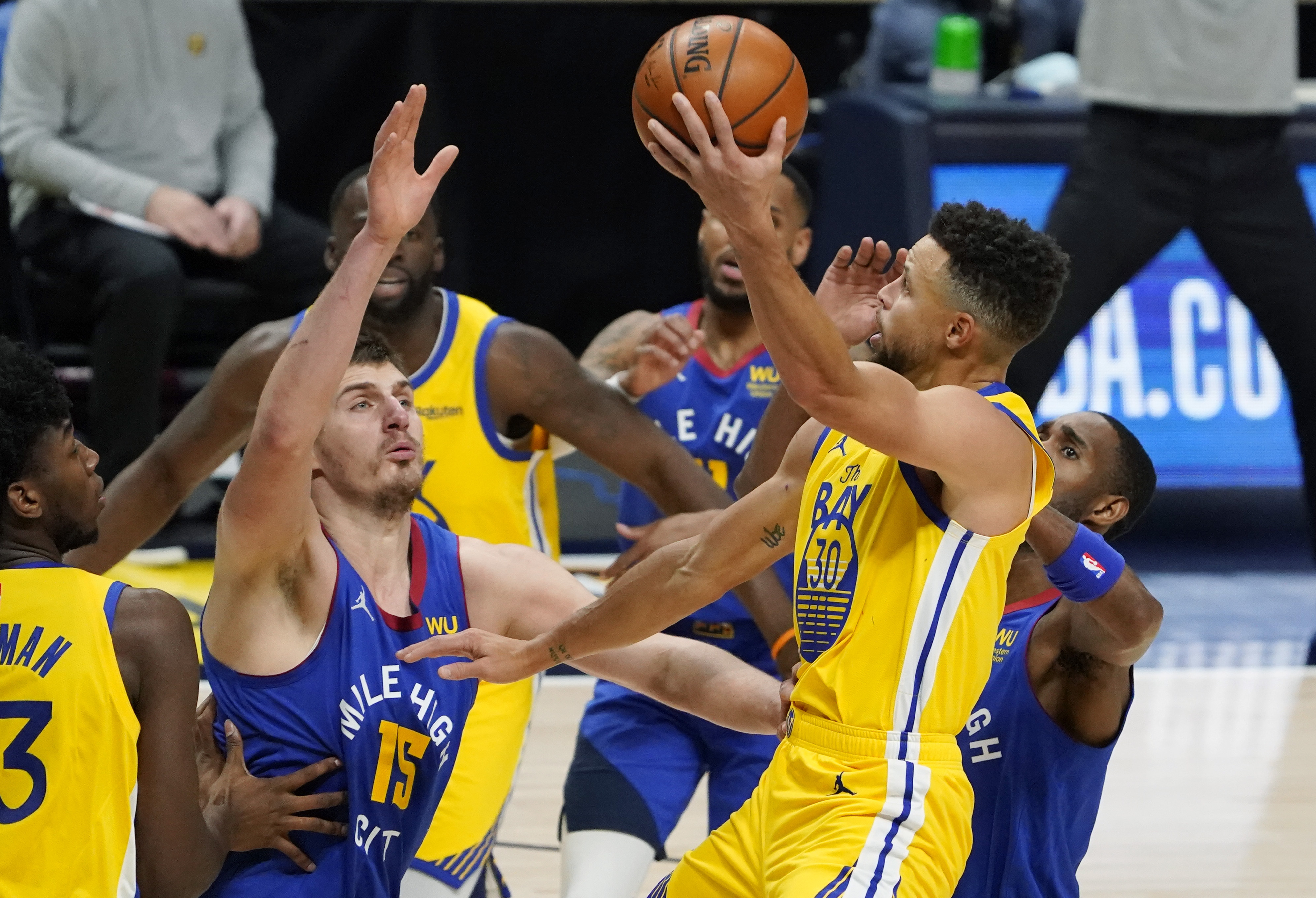 Golden State Warriors guard Stephen Curry, front right, drives as Denver Nuggets center Nikola Jokic defends during the second half of an NBA basketball game Thursday, Jan. 14, 2021, in Denver. The Nuggets won 114-104. (AP Photo/David Zalubowski)